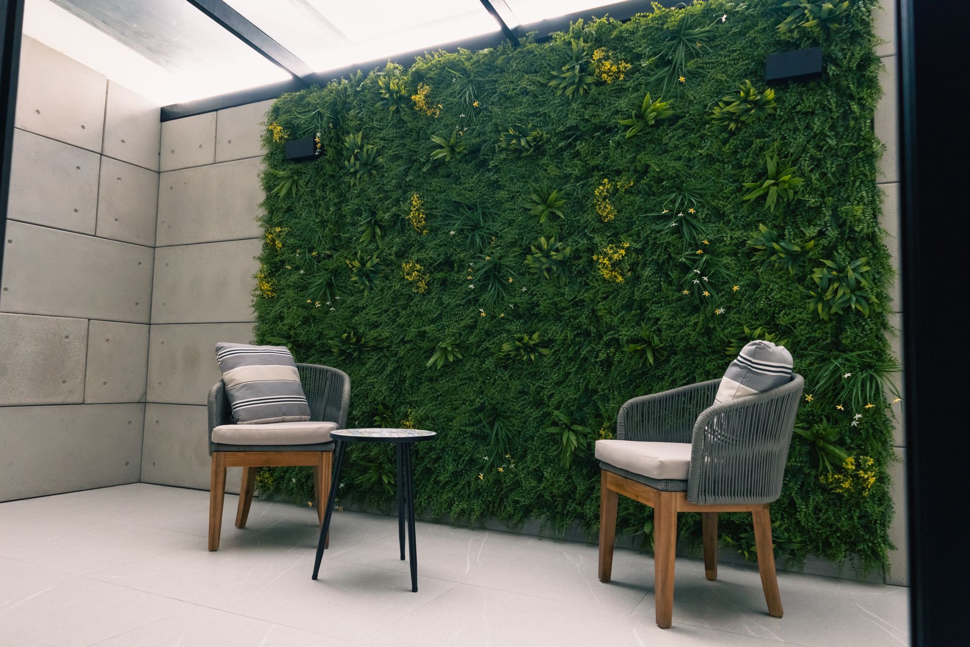 Two chairs and a table are sitting in front of a green wall.
