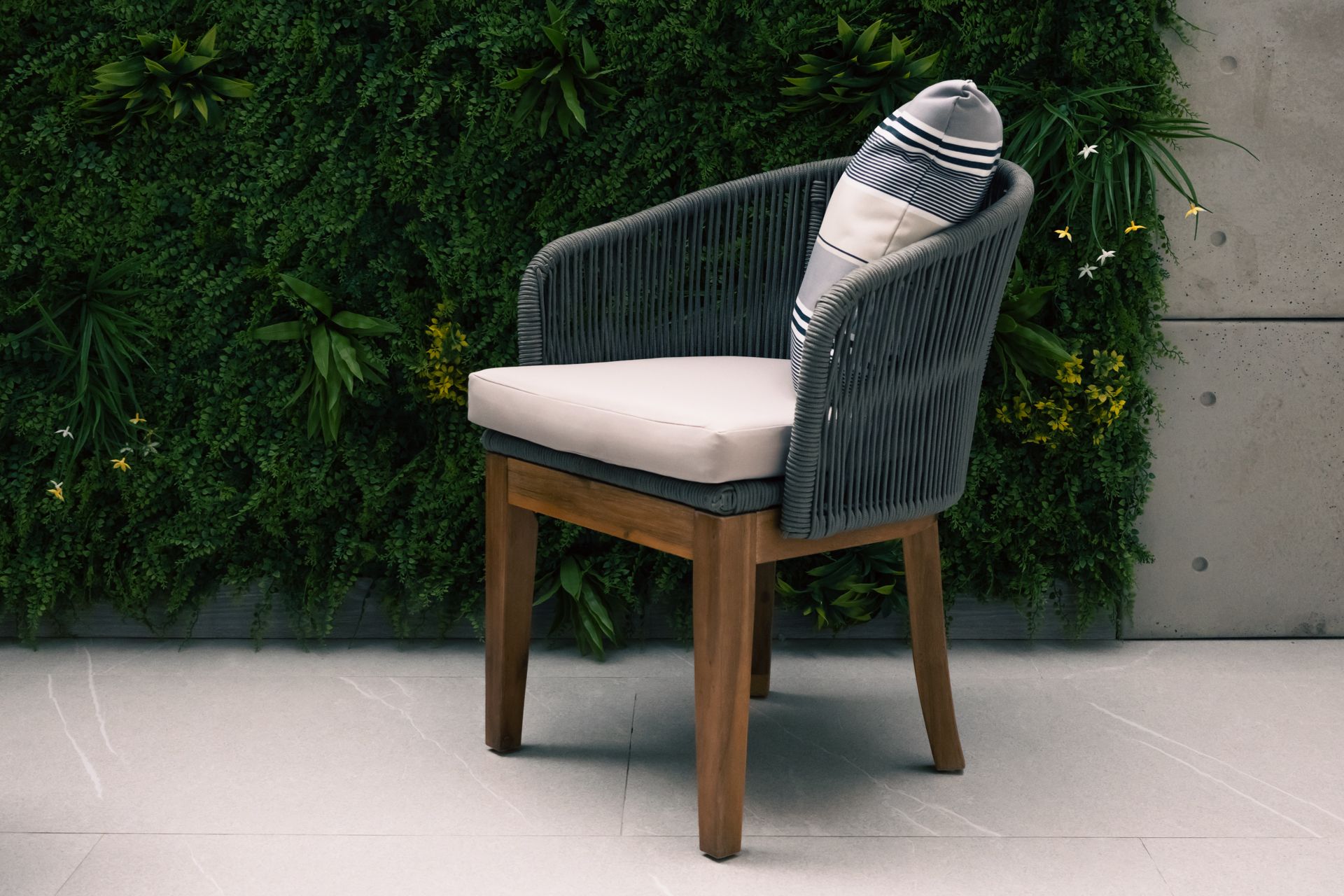 A chair with a pillow on it is sitting in front of a green wall.