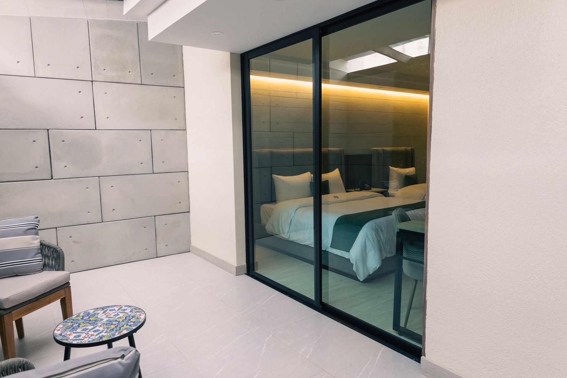 A bedroom with a sliding glass door leading to a balcony.