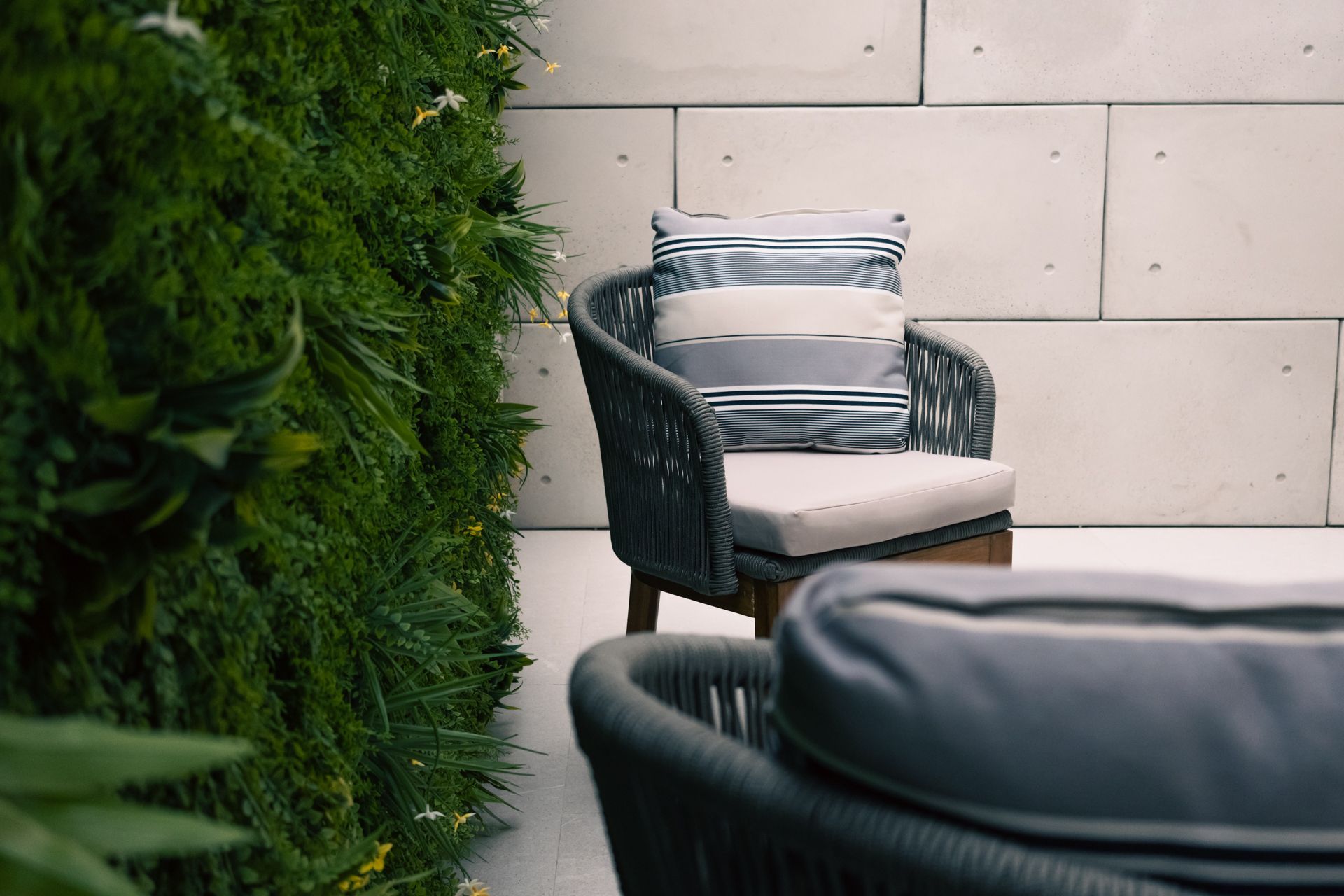 A chair and a couch are sitting next to each other on a patio.