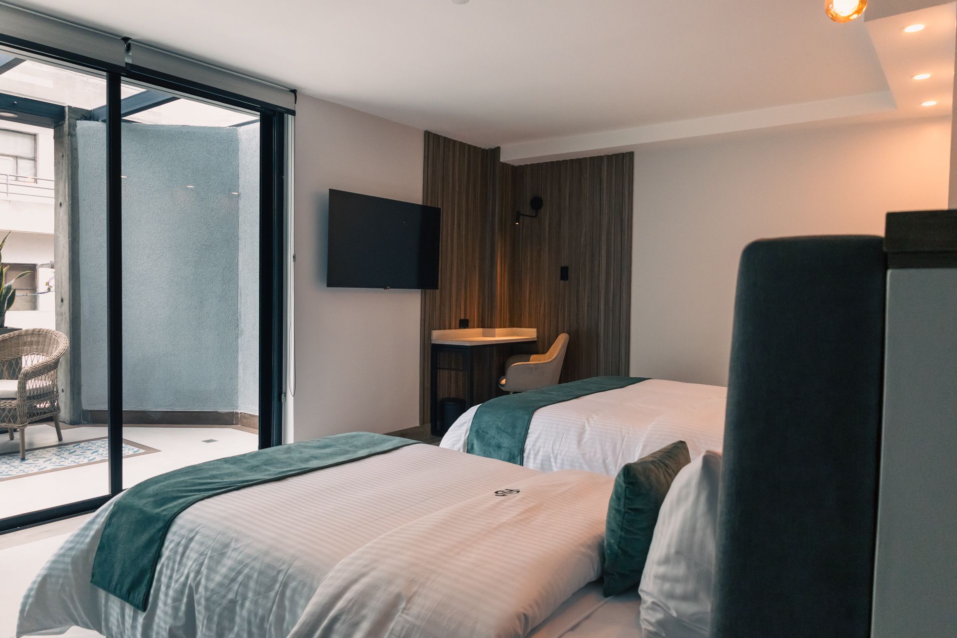 A hotel room with two beds , a desk and a television.