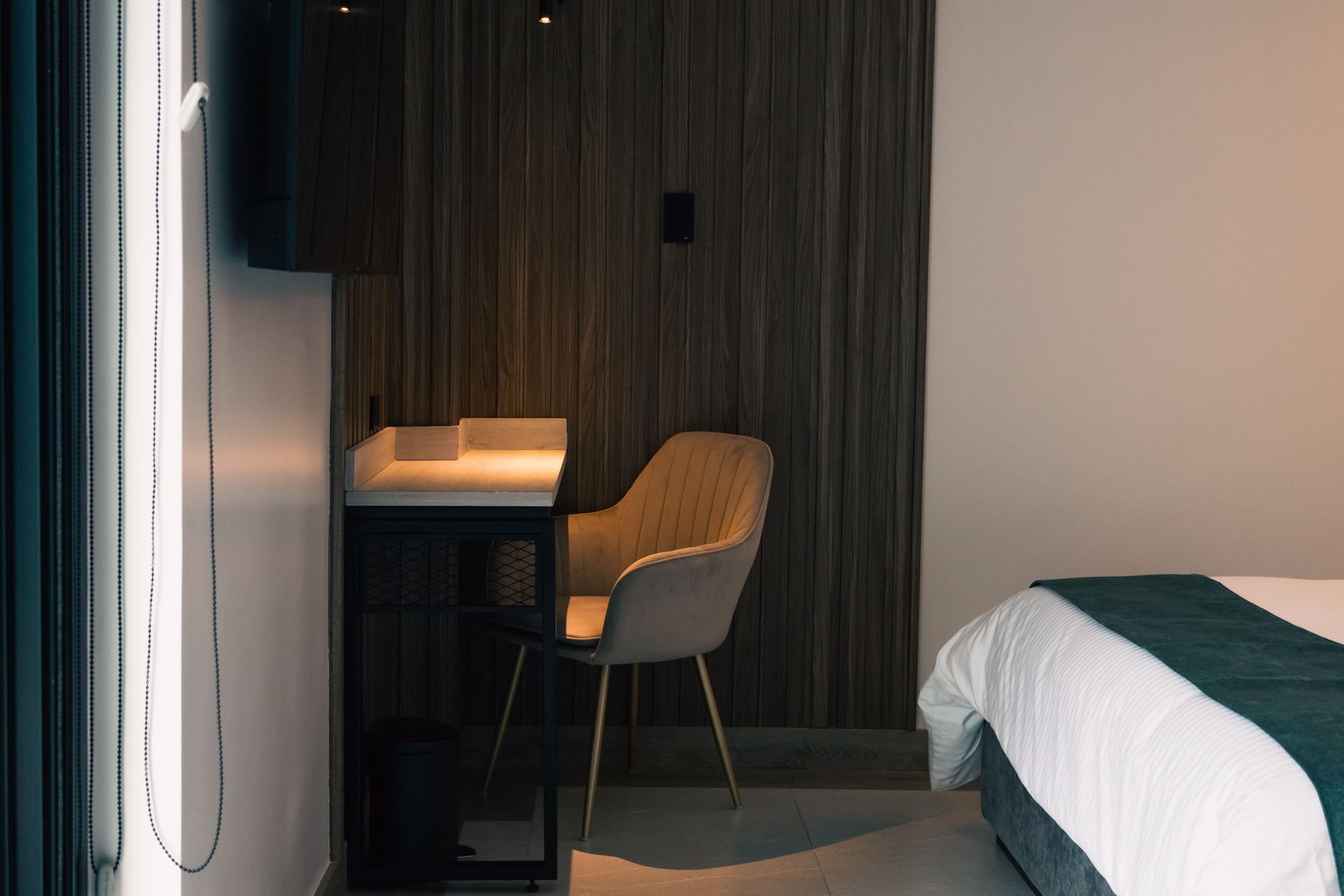 A hotel room with a bed , desk and chair.