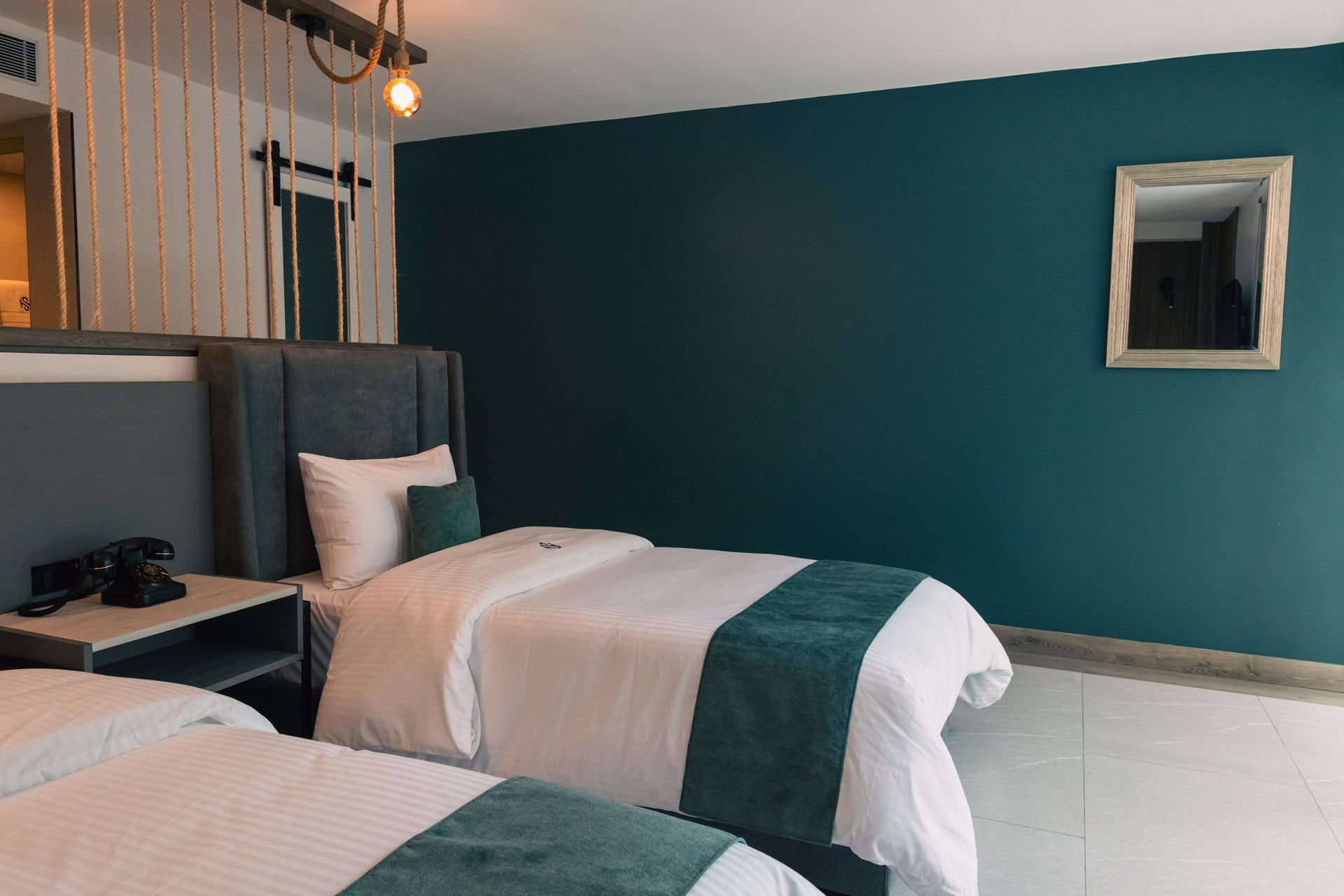 A hotel room with two beds and a mirror.