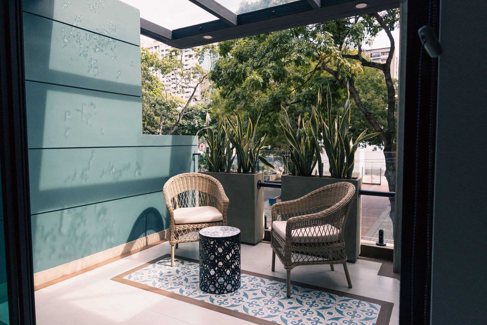 There are two chairs and a table on the balcony.