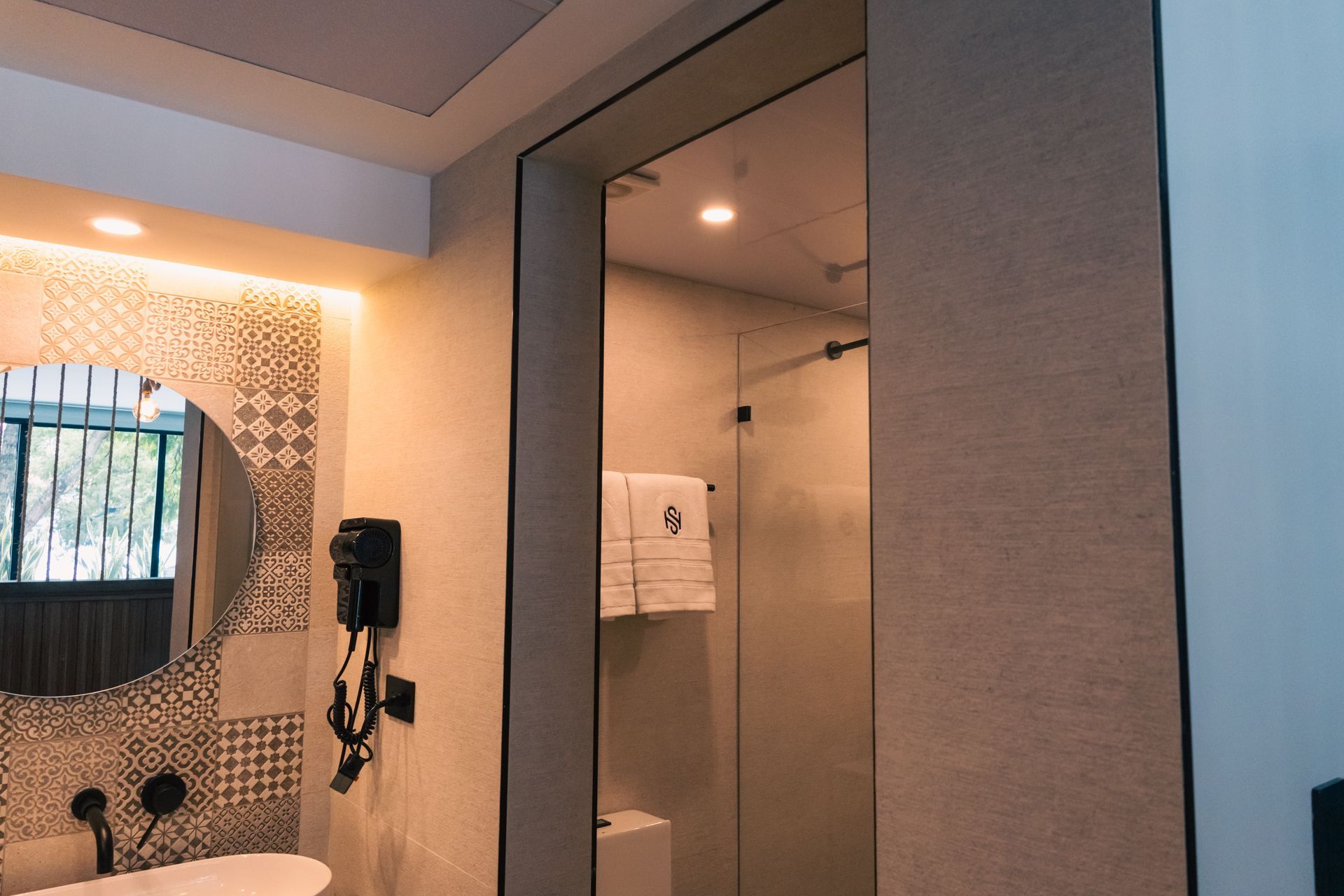 A bathroom with a sink , mirror and shower.