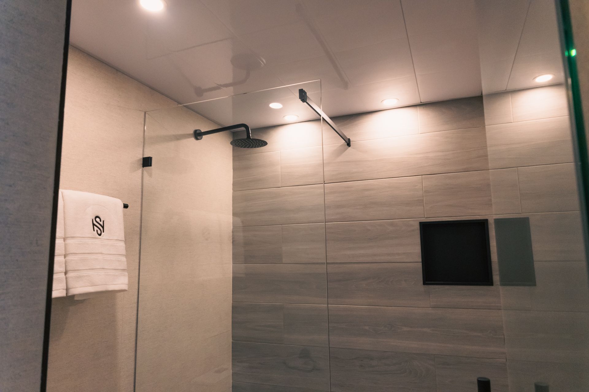 A bathroom with a walk in shower and a towel rack.