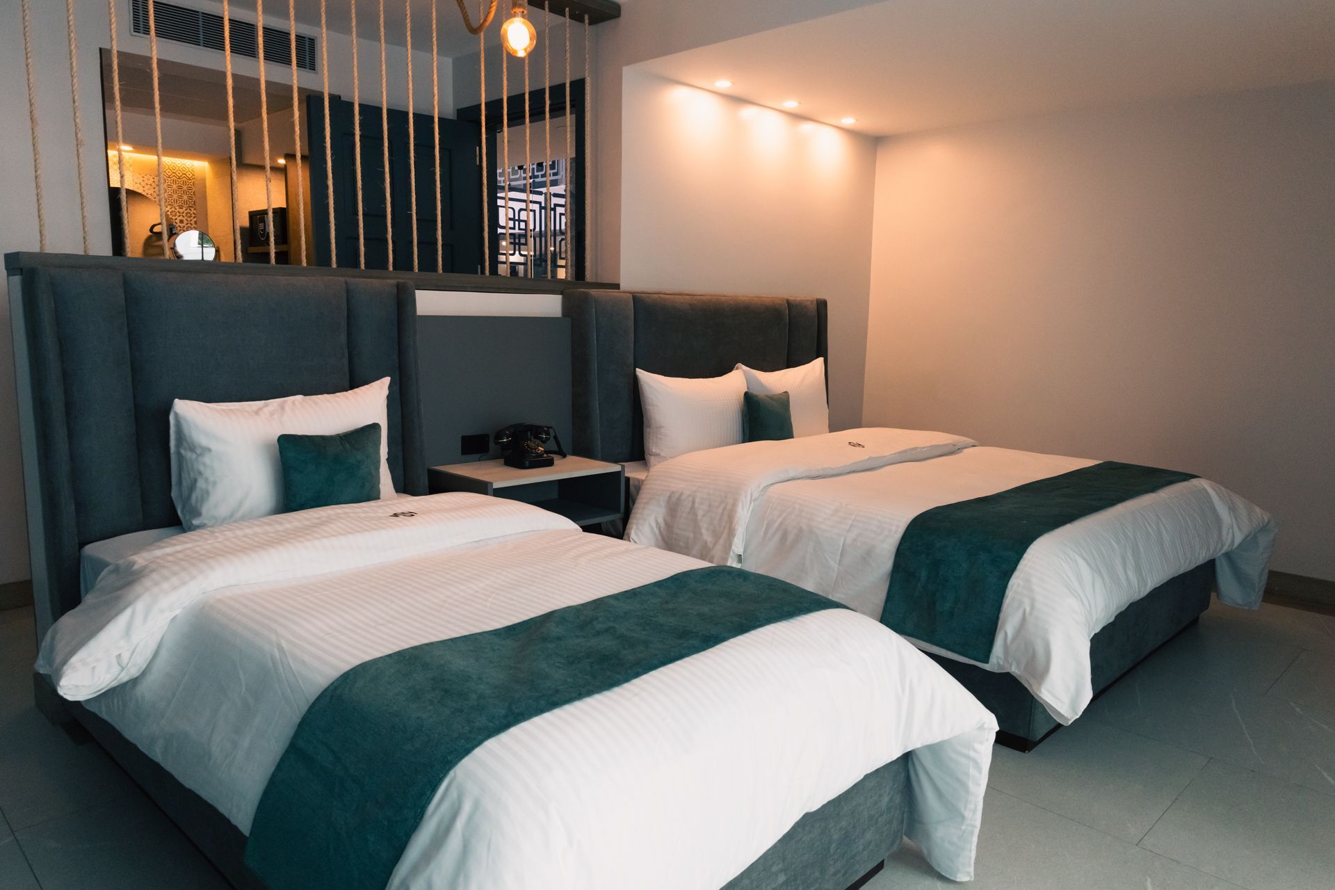 A hotel room with two beds and a mirror.