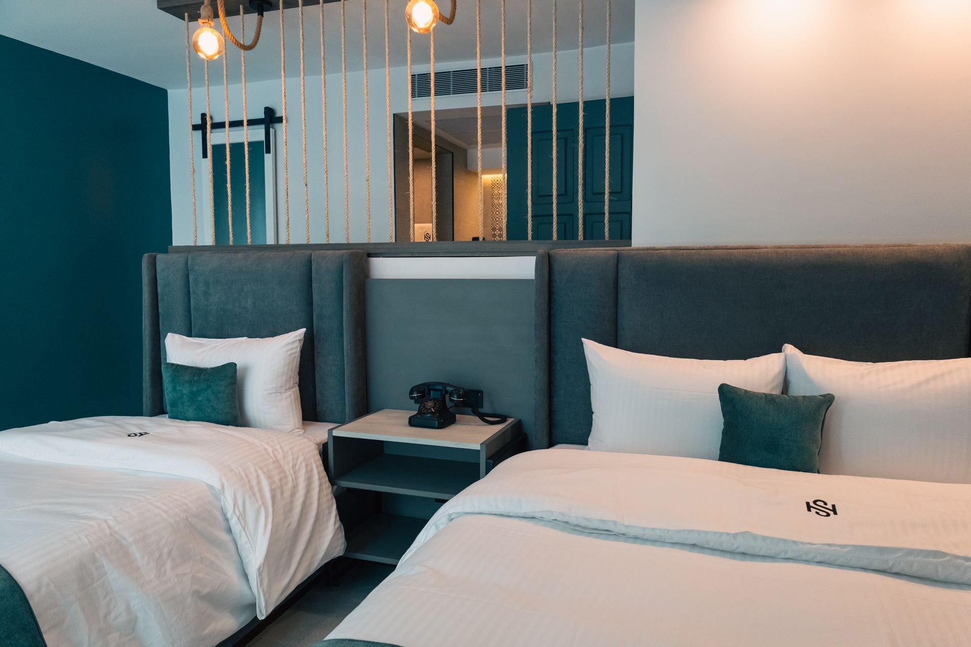 A hotel room with two beds and a nightstand.