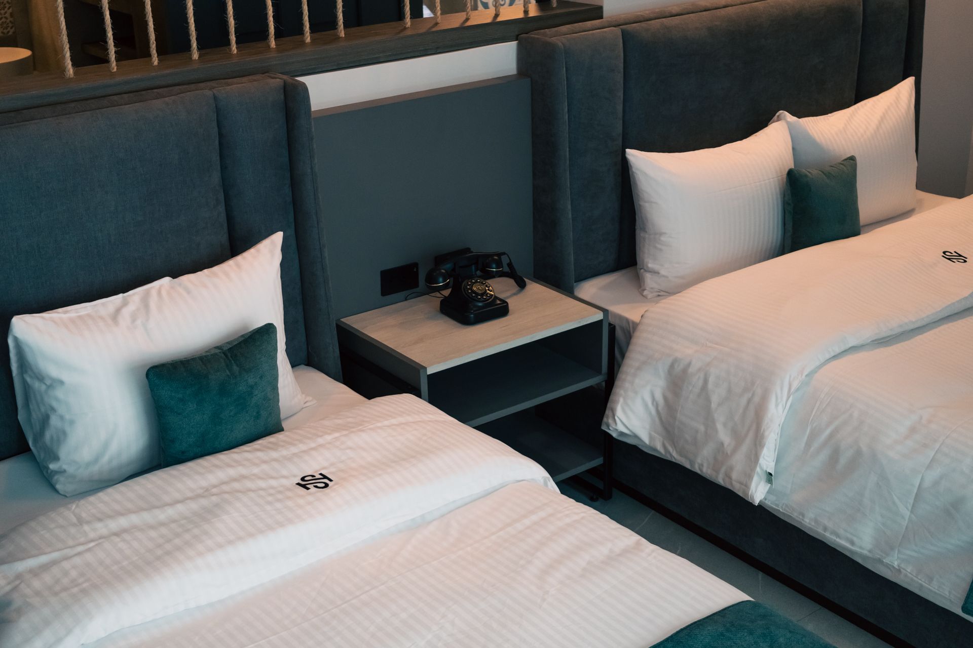 A hotel room with two beds and a phone on the nightstand.