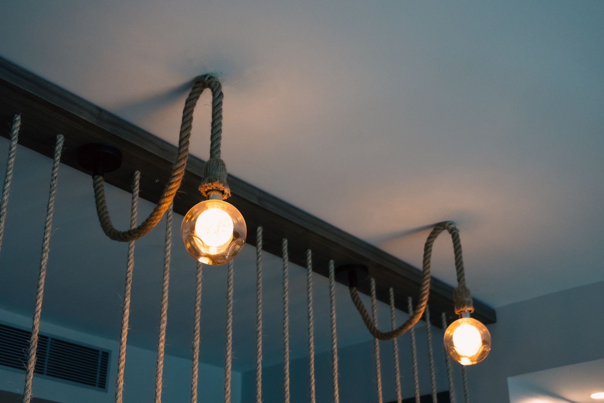 Three light bulbs are hanging from a rope from the ceiling