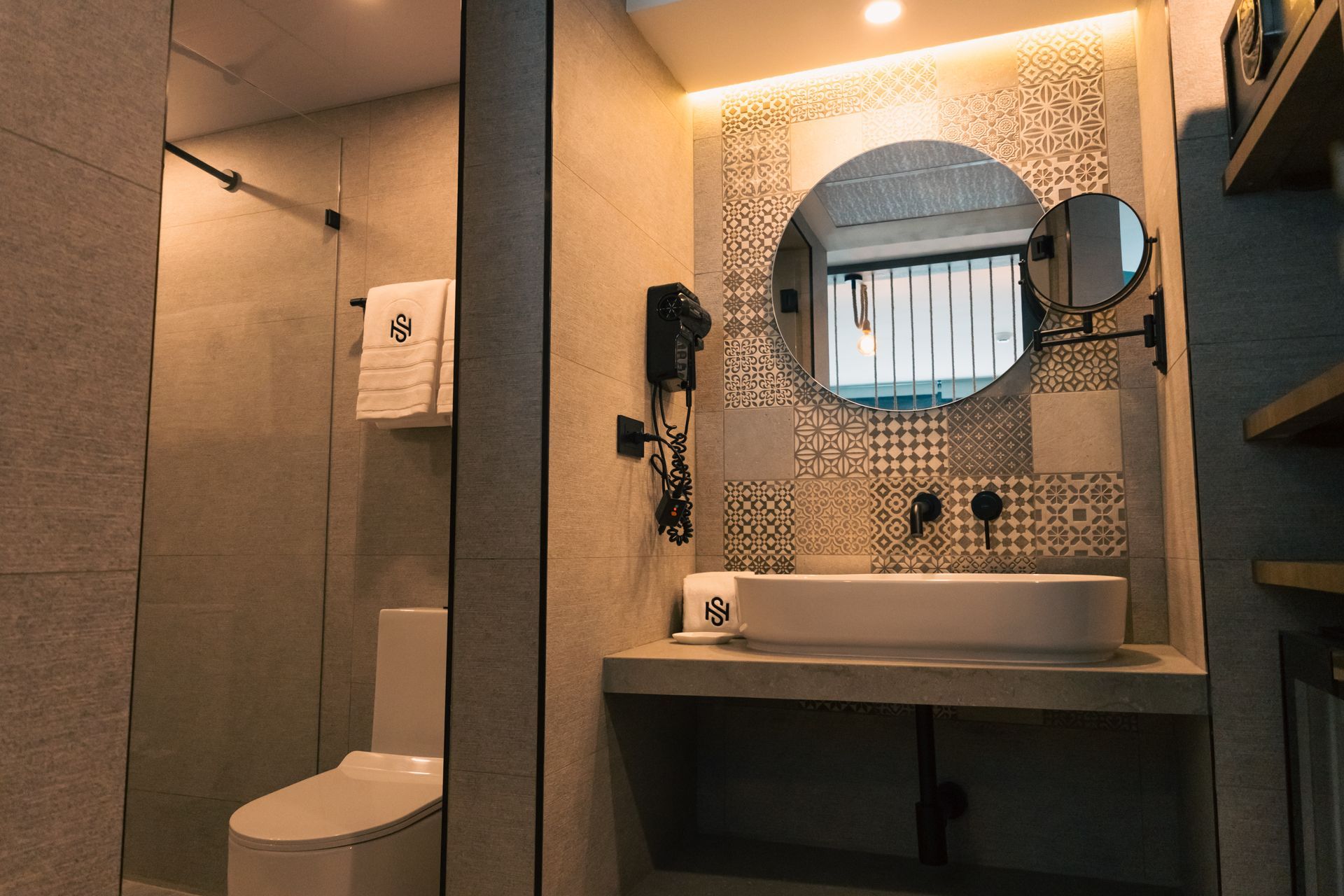 A bathroom with a toilet , sink , mirror and shower.