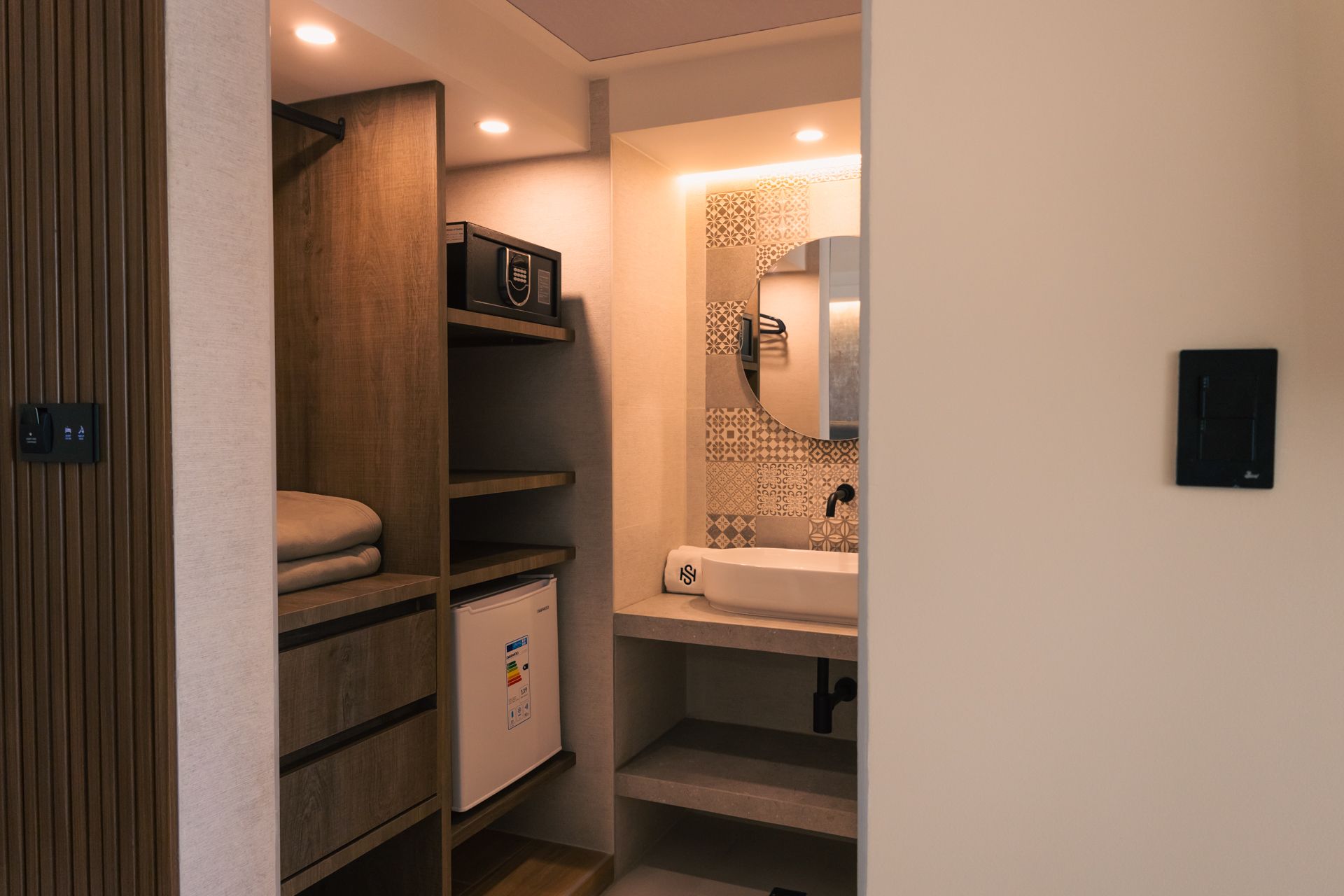 A bathroom with a sink , mirror and a walk in closet.