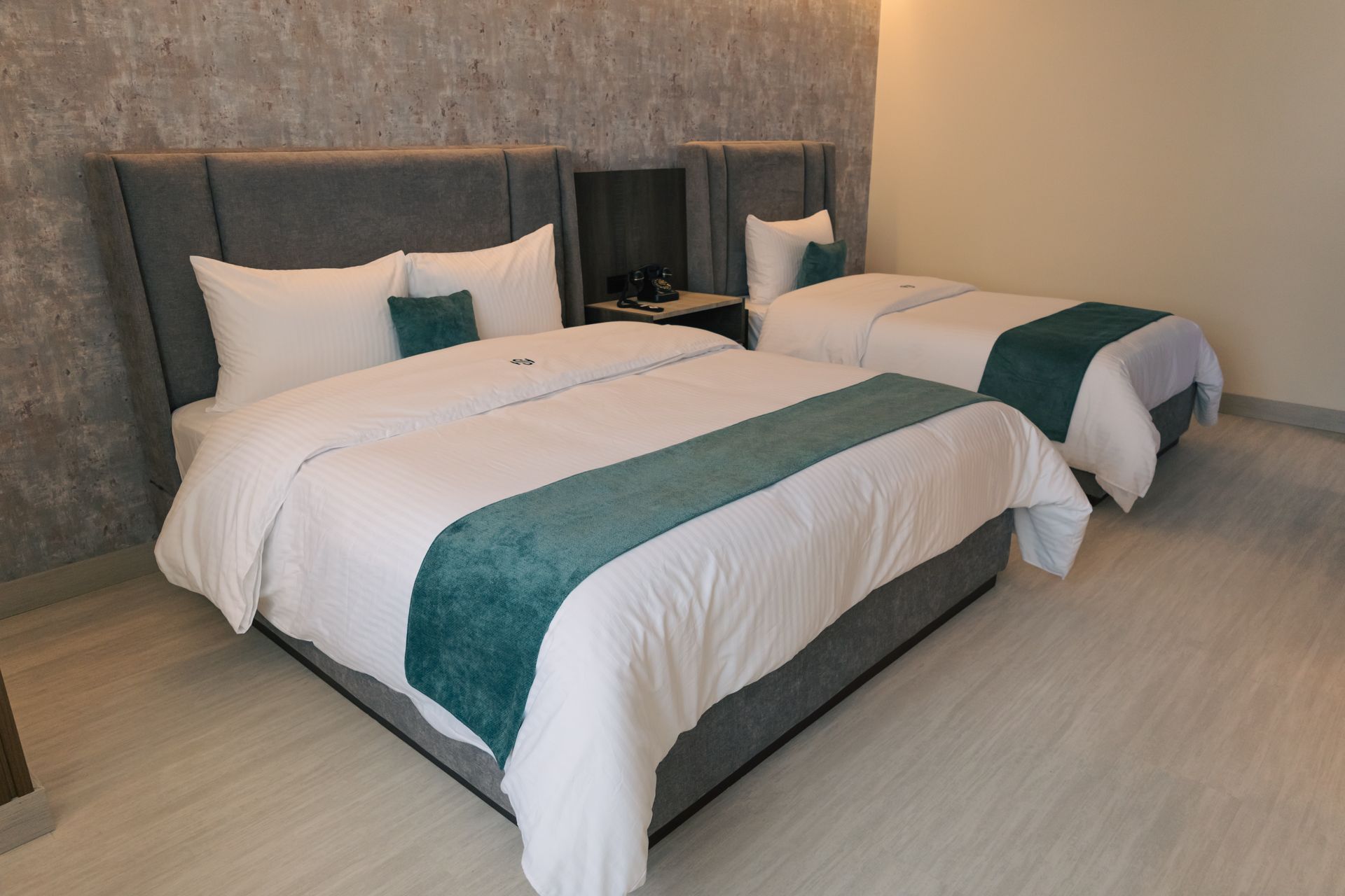 A hotel room with two beds and a television.