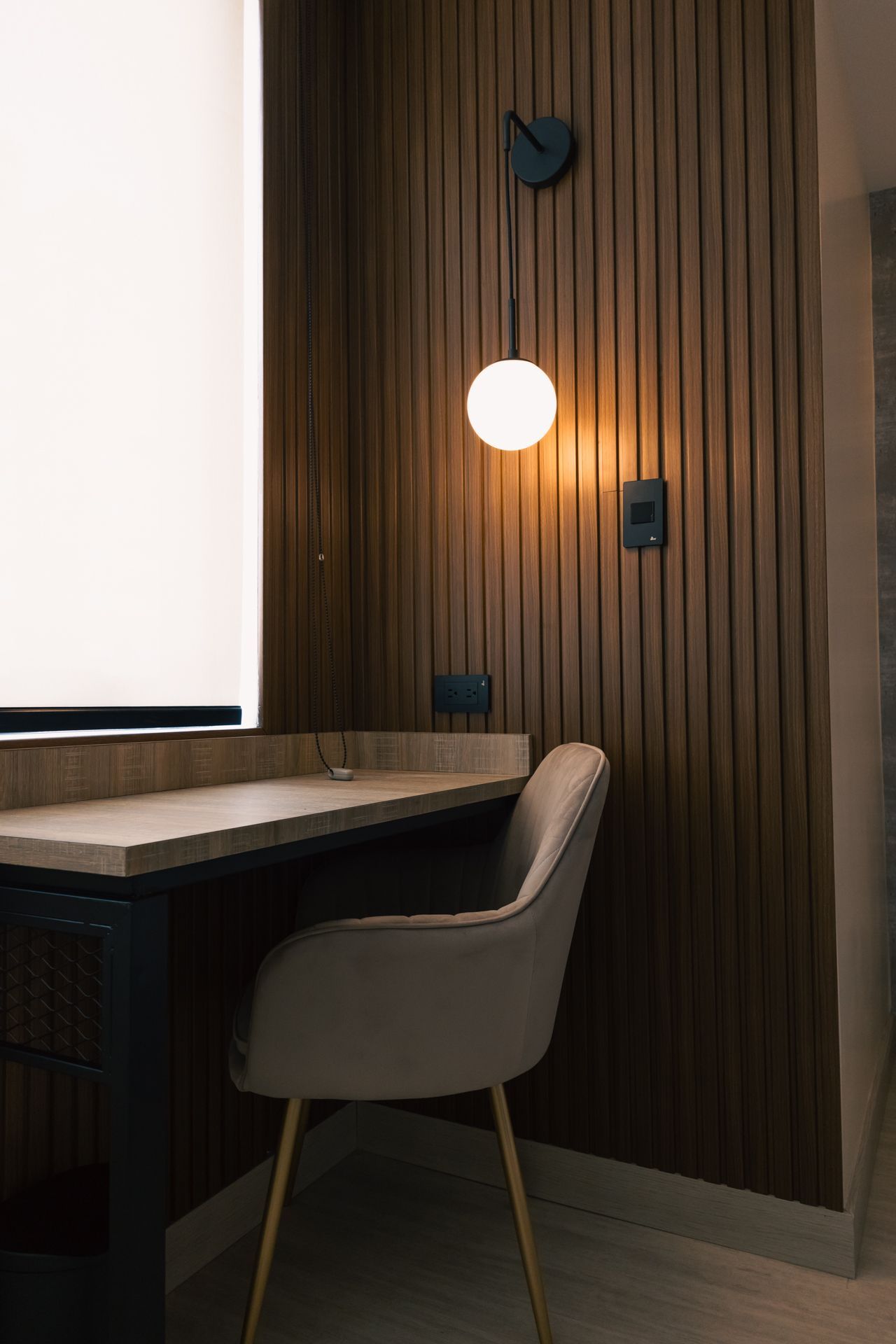 A chair is sitting at a desk in a room next to a window.