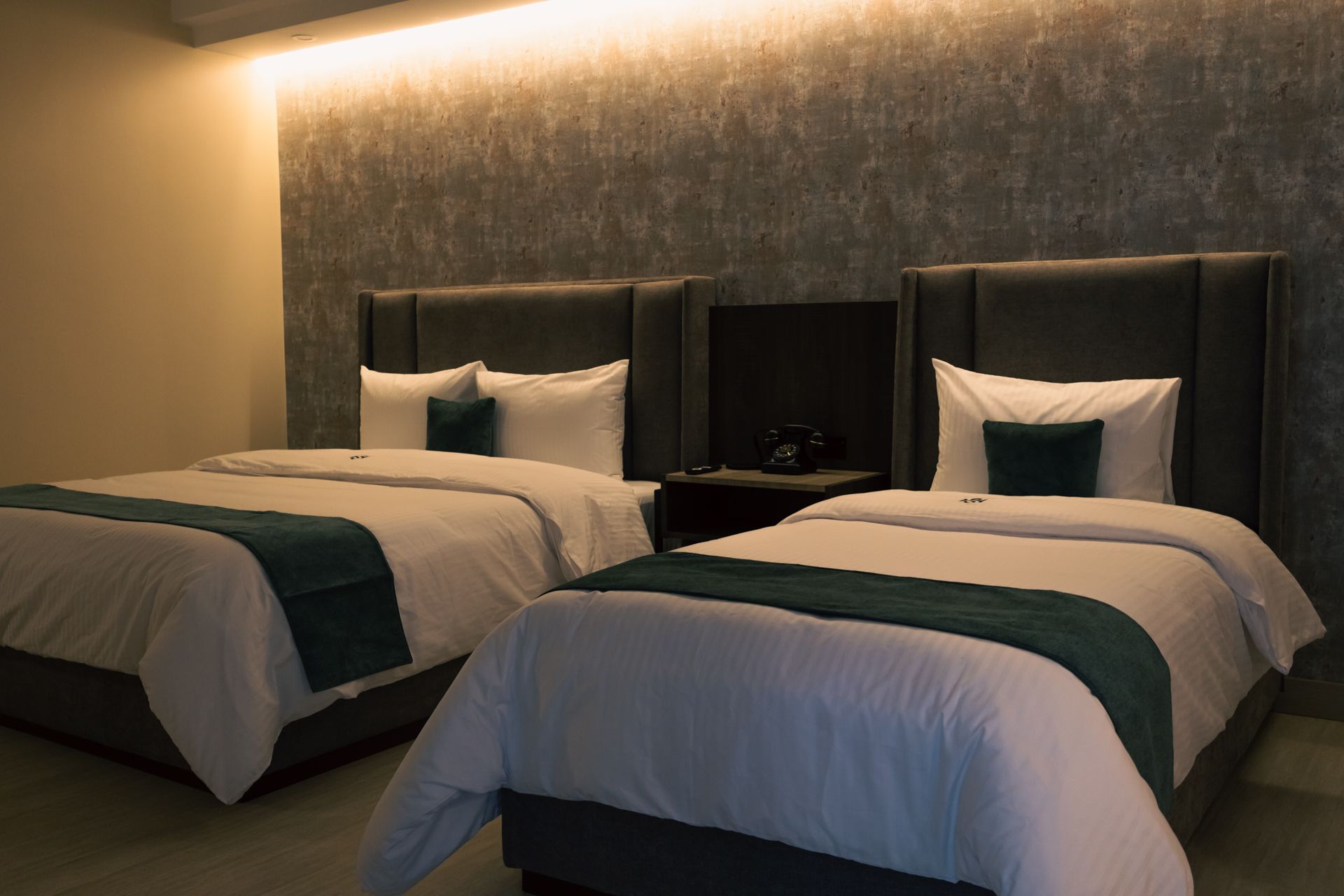 A hotel room with two beds and a television.