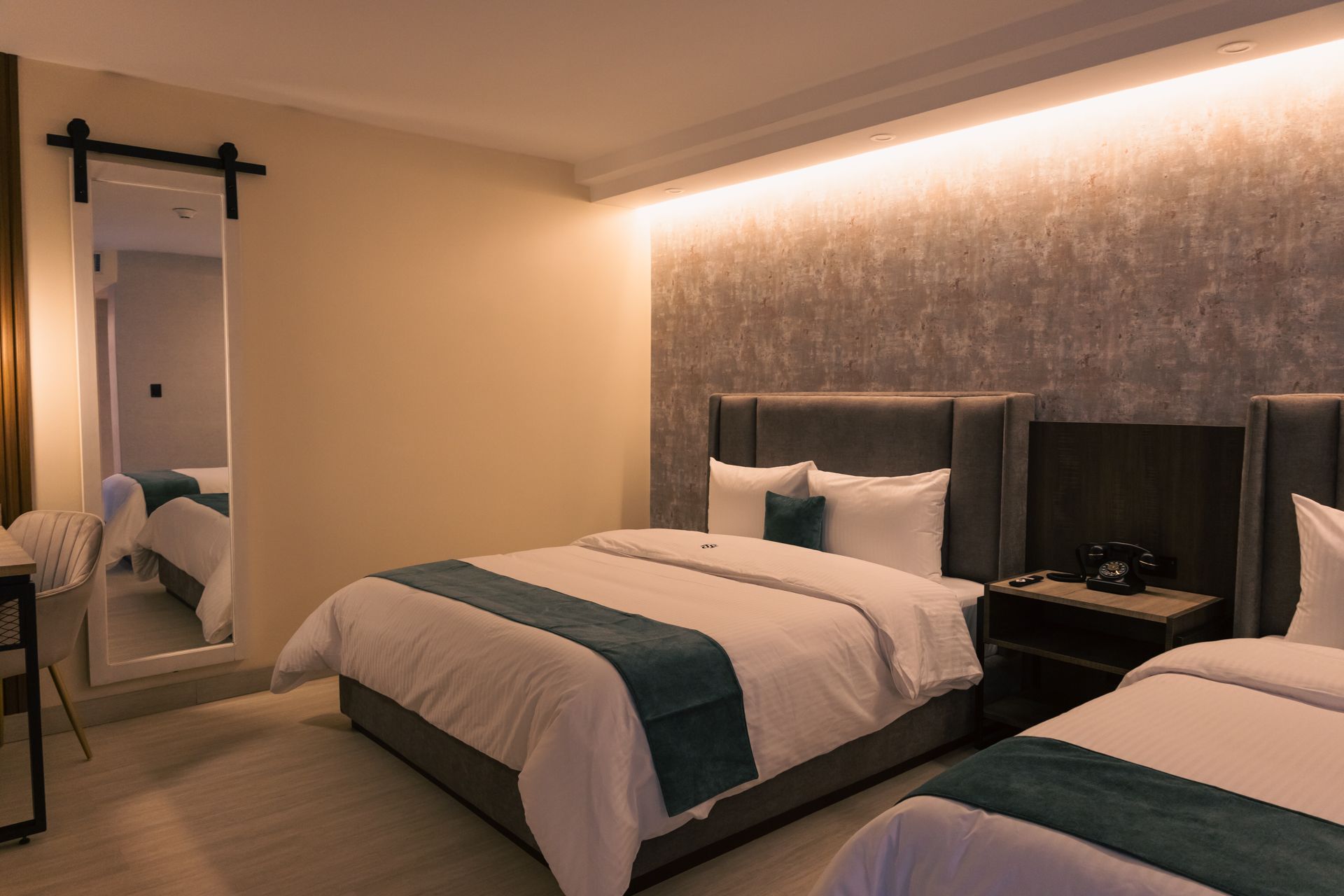 A hotel room with two beds and a large mirror.
