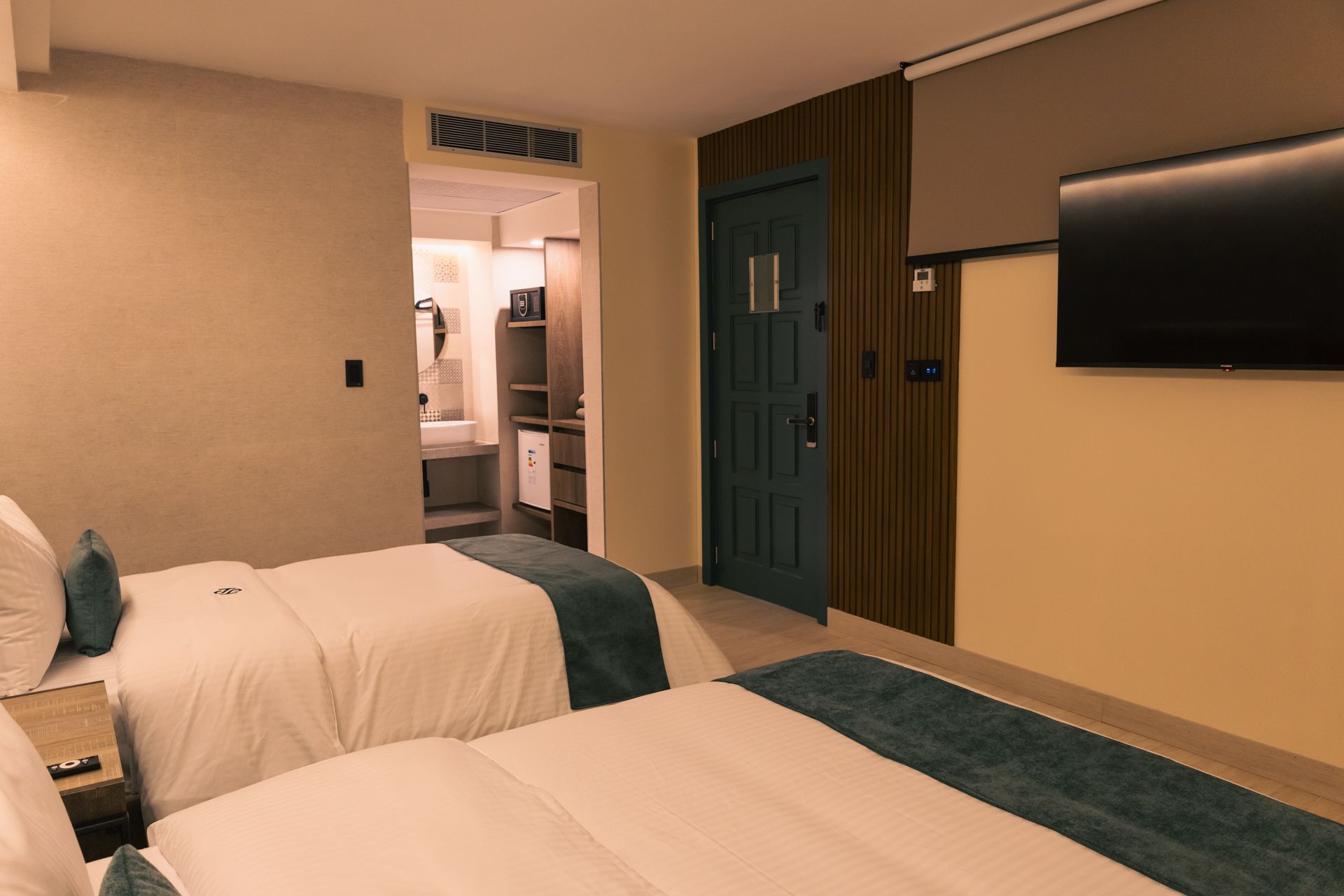 A hotel room with two beds and a flat screen tv.