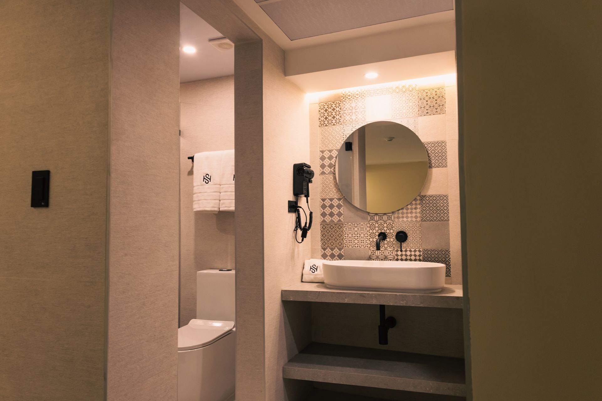 A bathroom with a sink , mirror and towel dryer.
