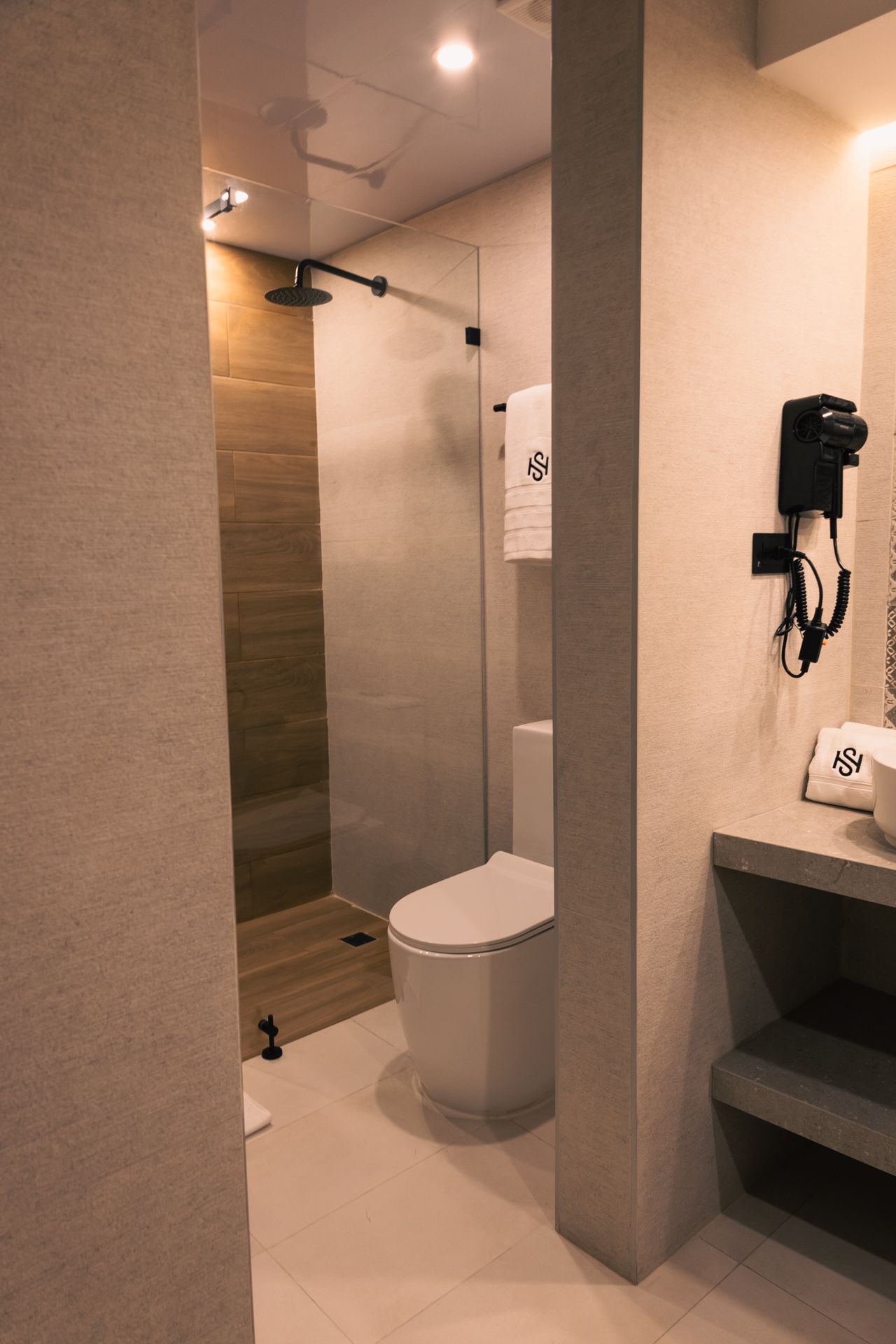 A bathroom with a toilet , sink and shower.