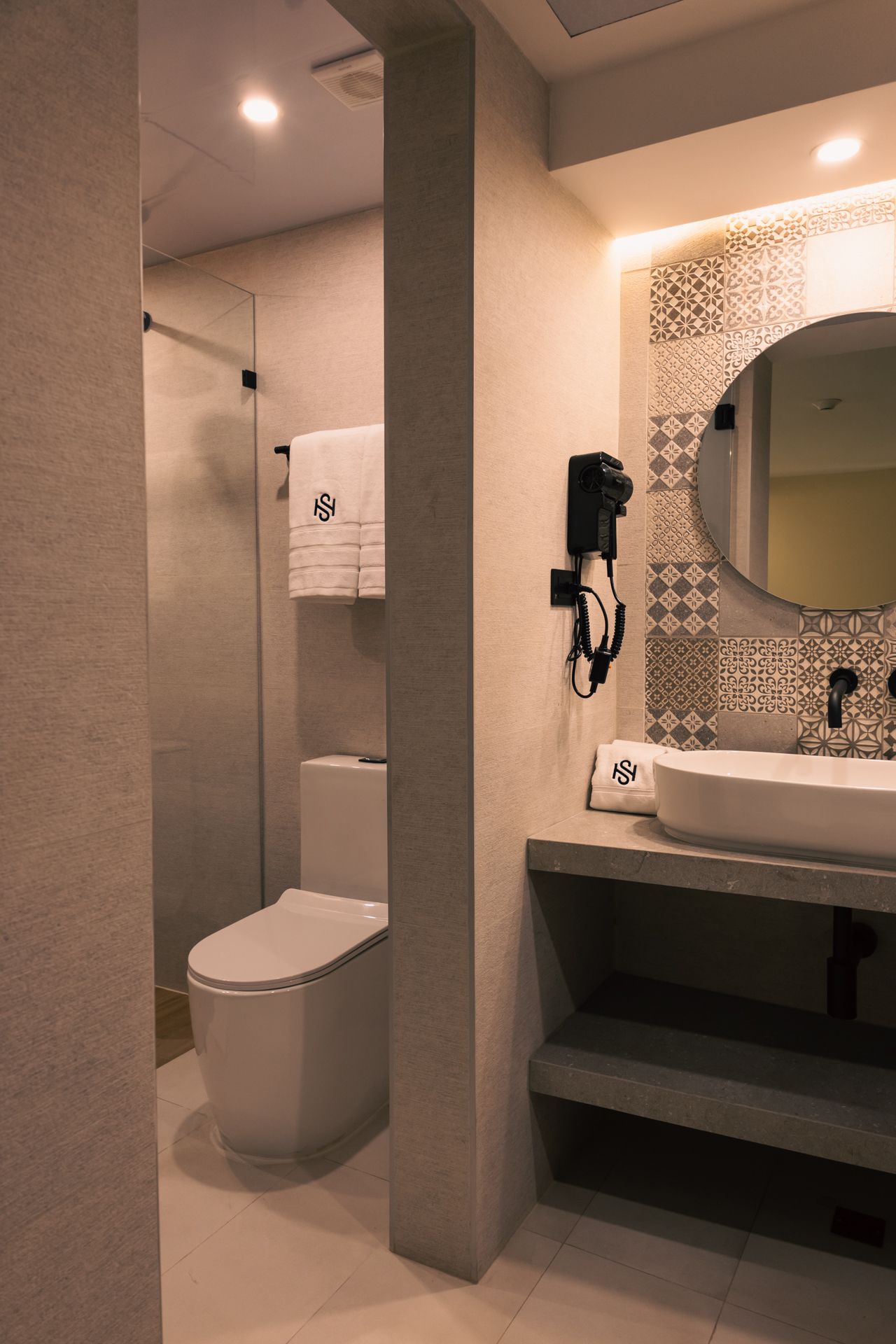 A bathroom with a toilet , sink and mirror.