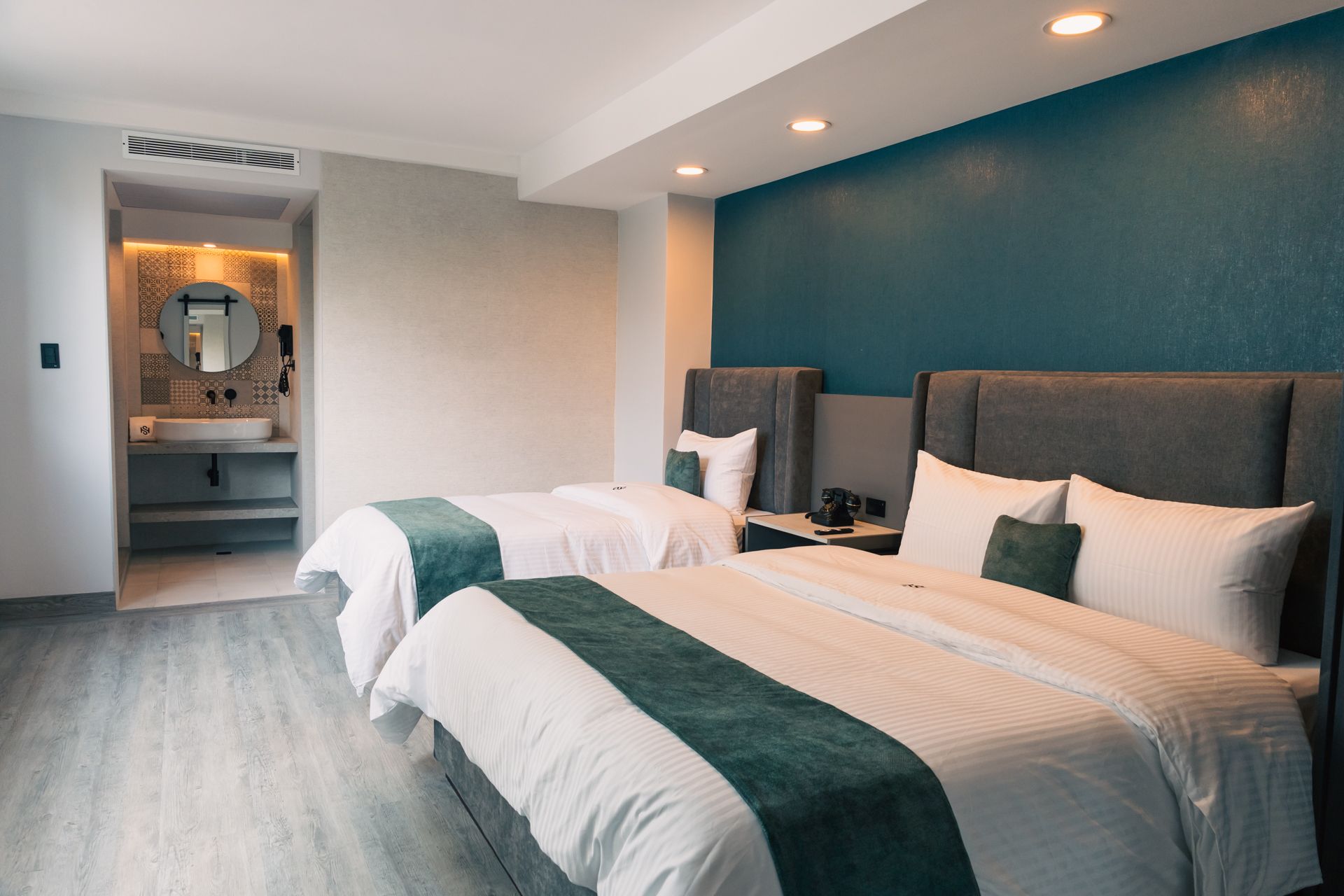 A hotel room with two beds and a bathroom.