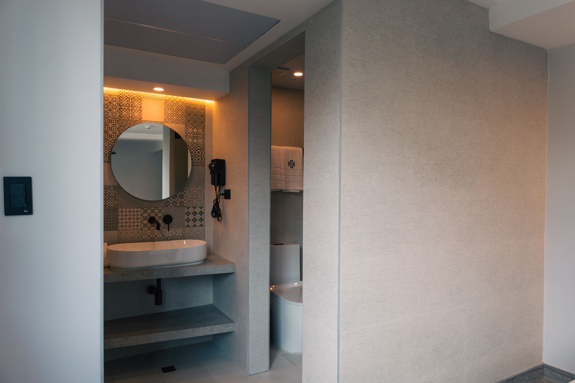 A bathroom with a sink , mirror and toilet.