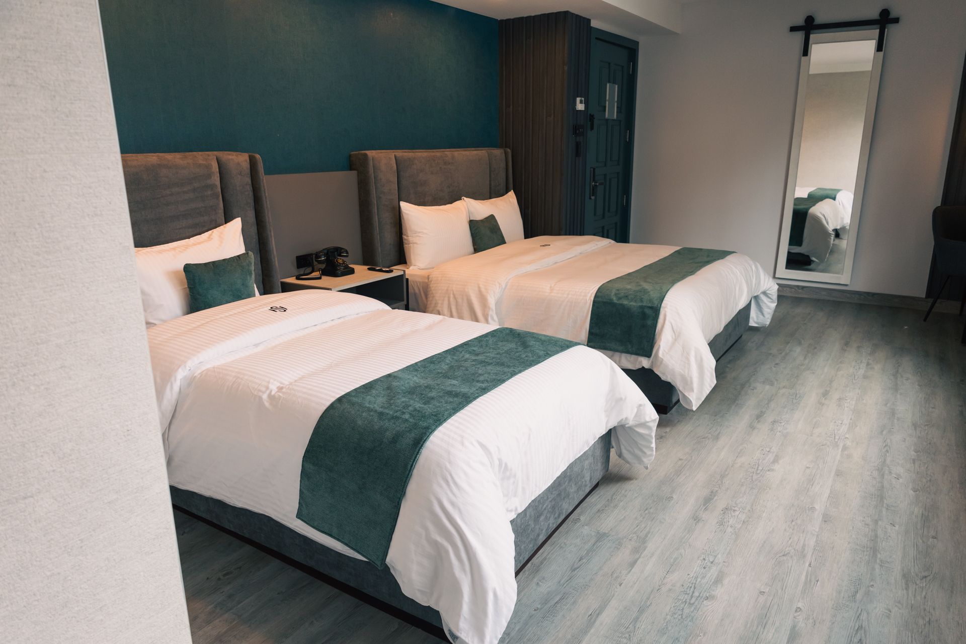 A hotel room with two beds and a mirror.
