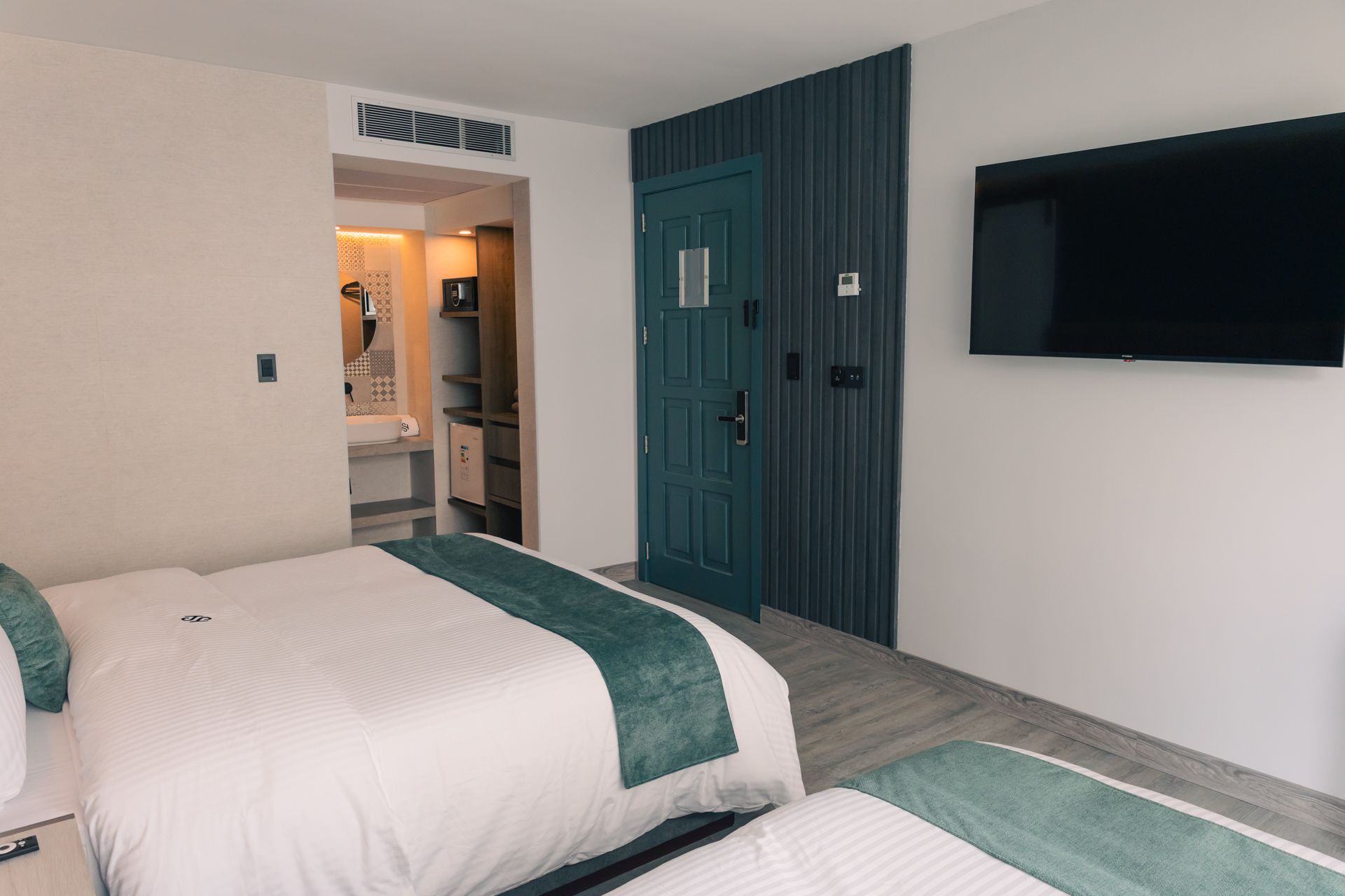 A hotel room with two beds and a flat screen tv.