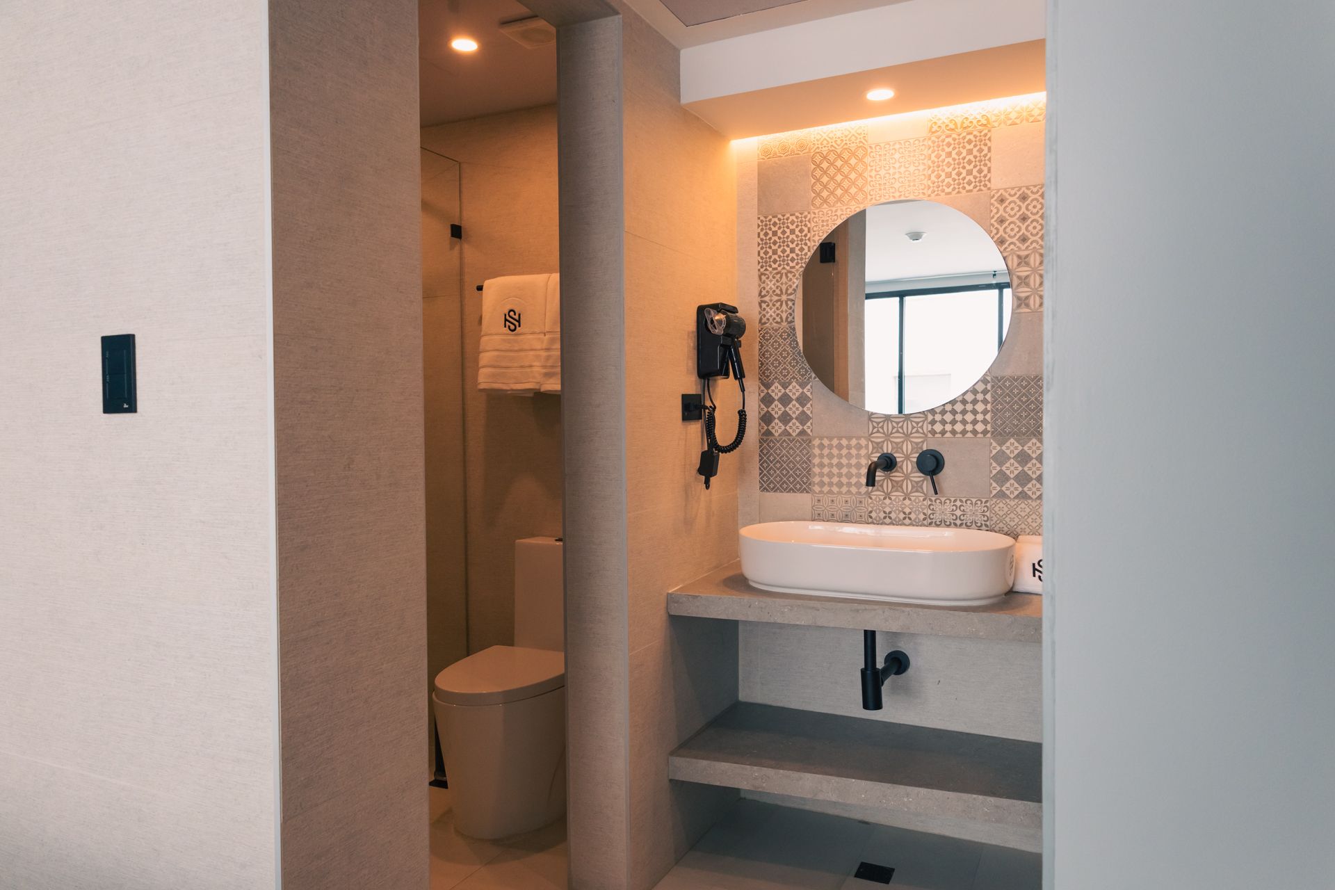 A bathroom with a sink , toilet and mirror.