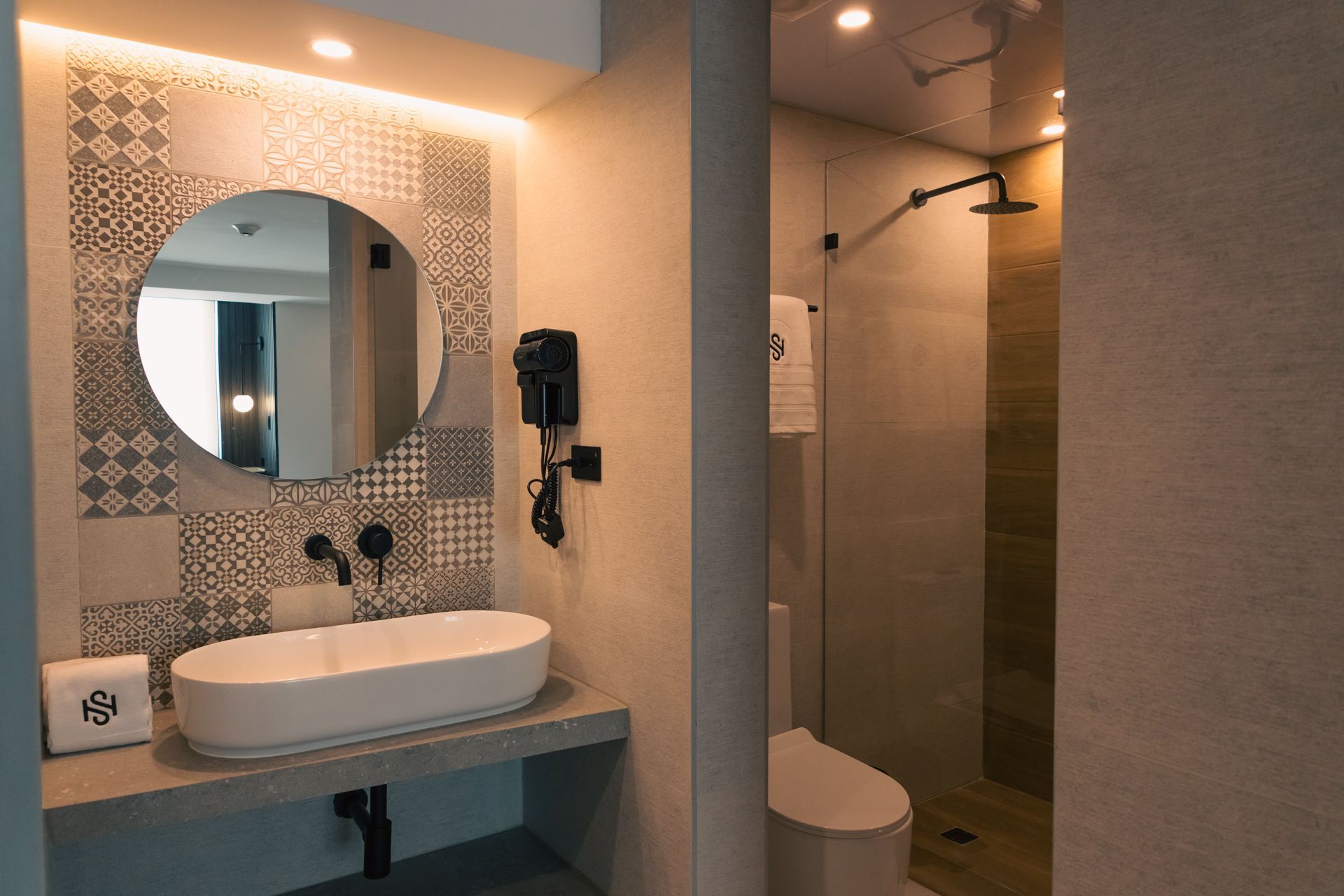 A bathroom with a sink , toilet , mirror and shower.