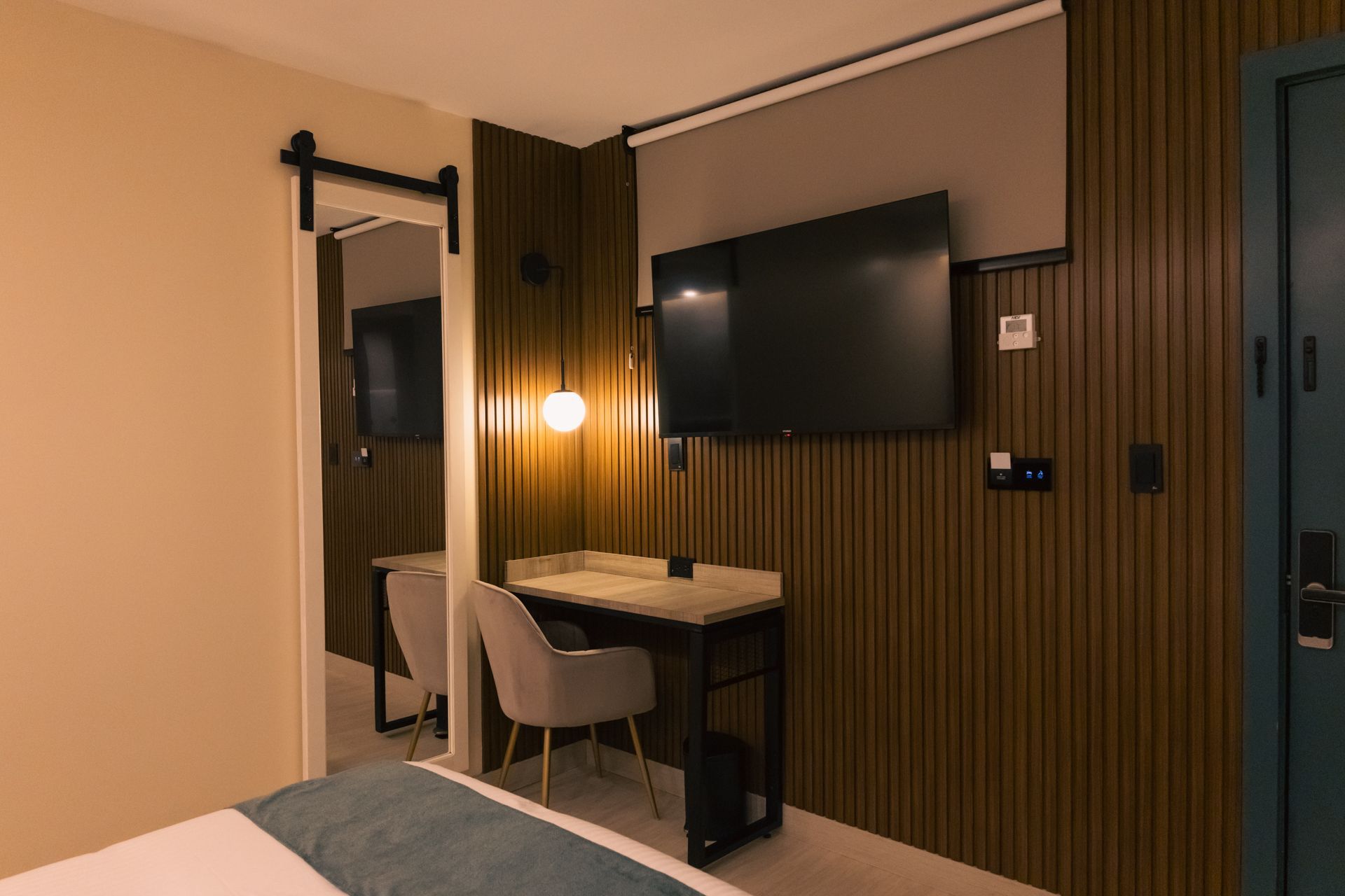 A hotel room with a bed , desk , chair and television.