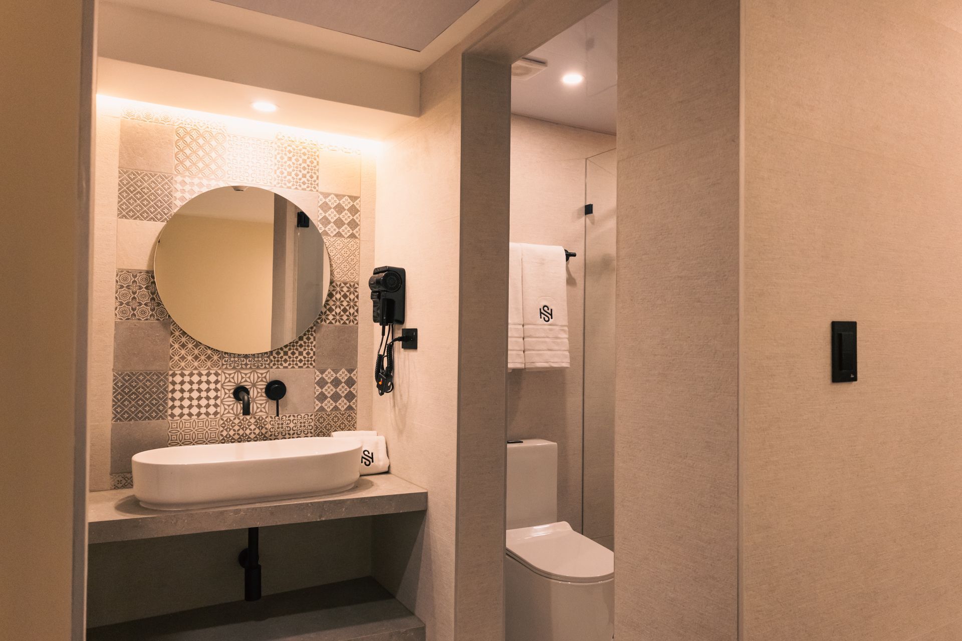 A bathroom with a sink , toilet and mirror.