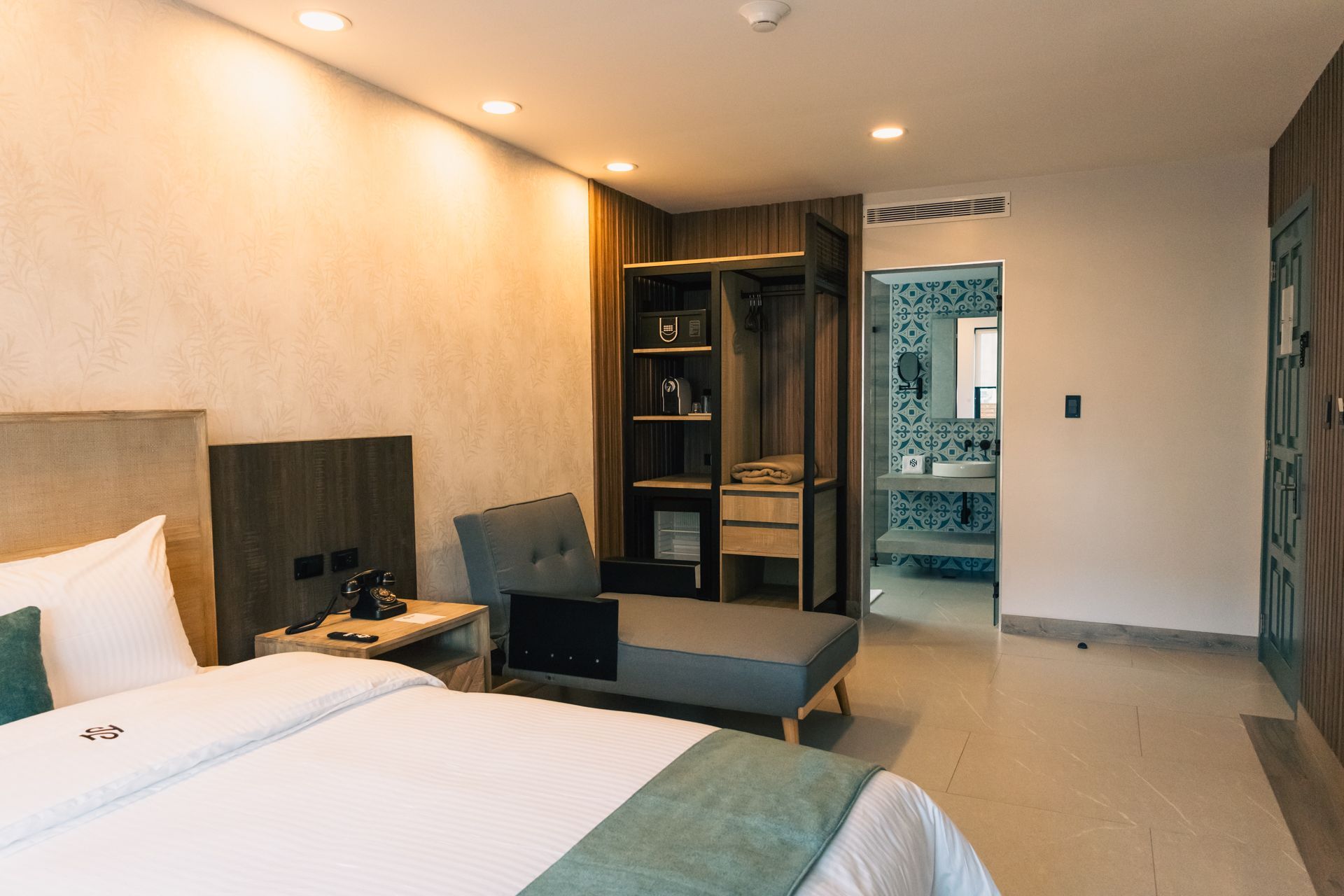A hotel room with a bed , chair , and closet.