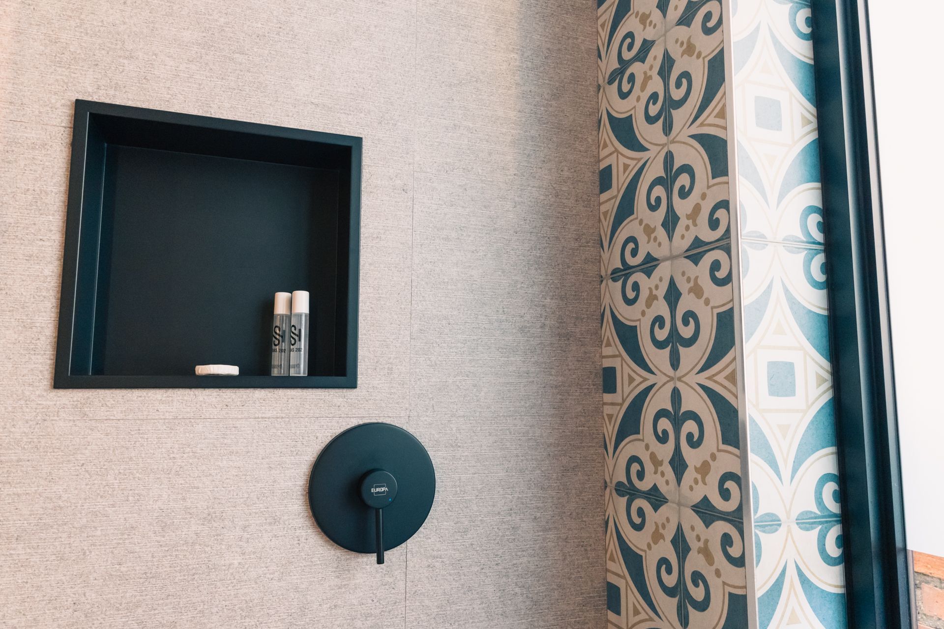 A bathroom with a shelf and a shower curtain.