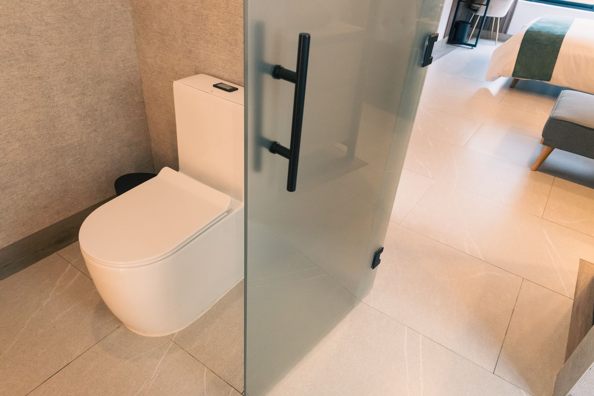 A bathroom with a toilet and a glass door