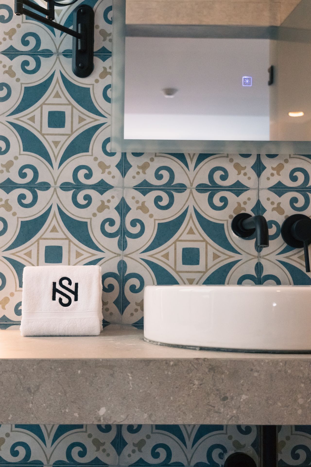 A bathroom with a sink and a towel with the letter s on it