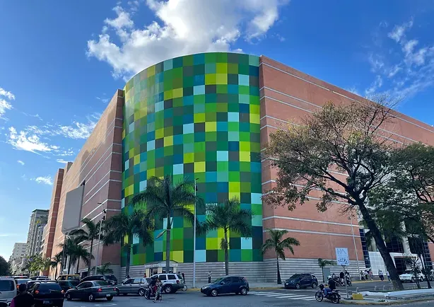 A large building with a lot of cars parked in front of it.