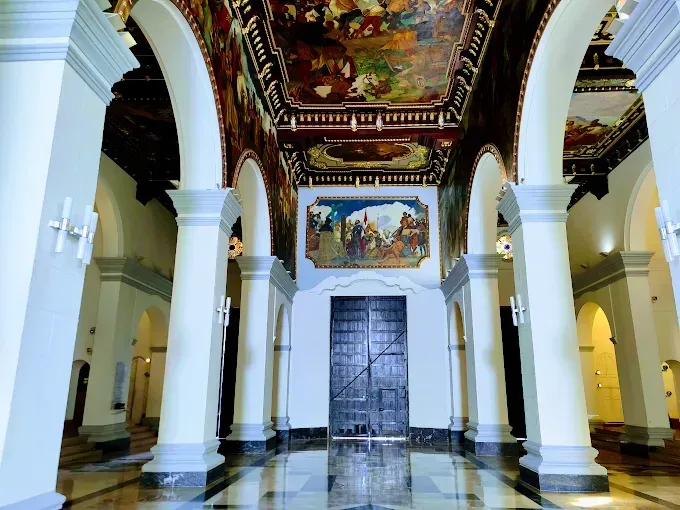 A church with arches and a painting on the ceiling