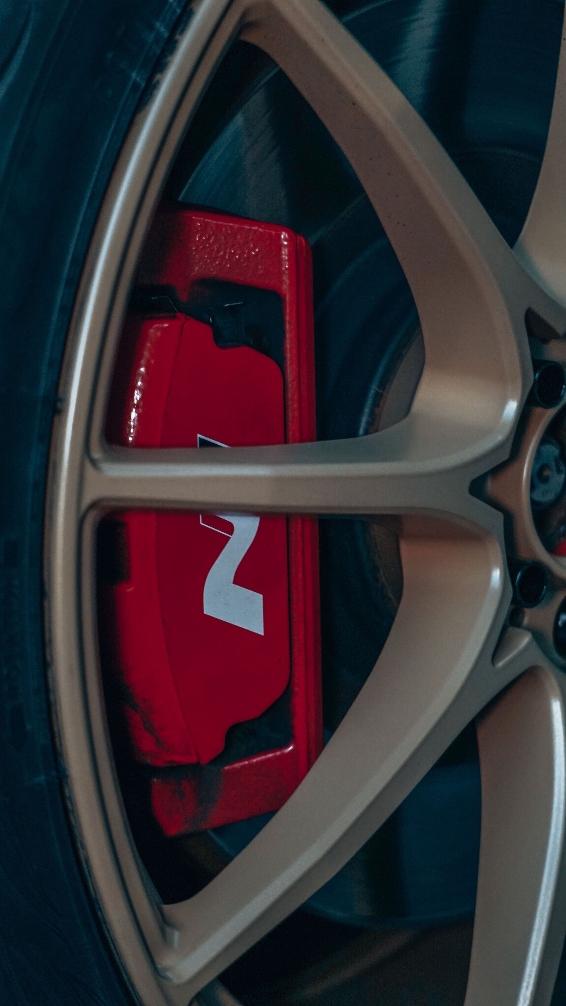 Red brake caliper behind a silver alloy wheel spoke.