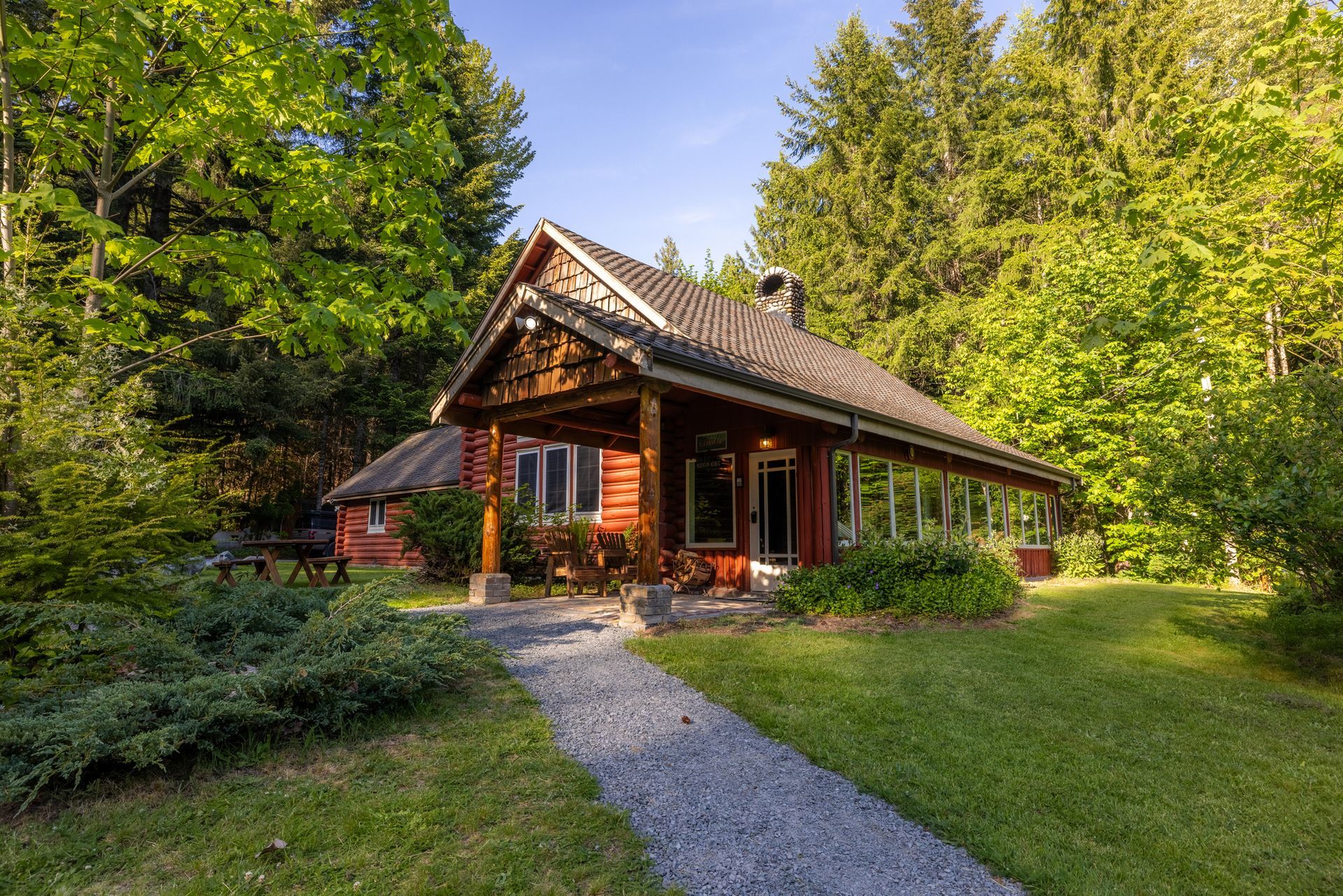 A large red log cabin in the middle of a forest