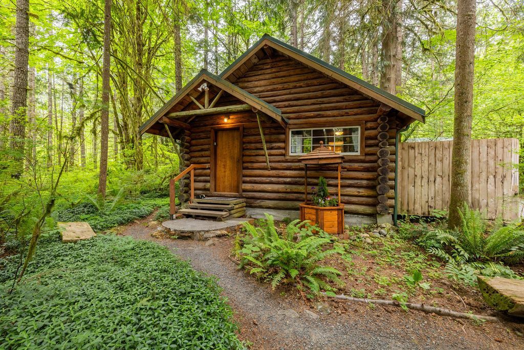 A small log cabin in the middle of a forest.