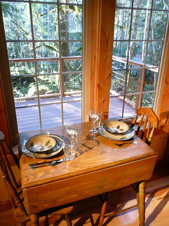 A wooden table with plates and utensils on it