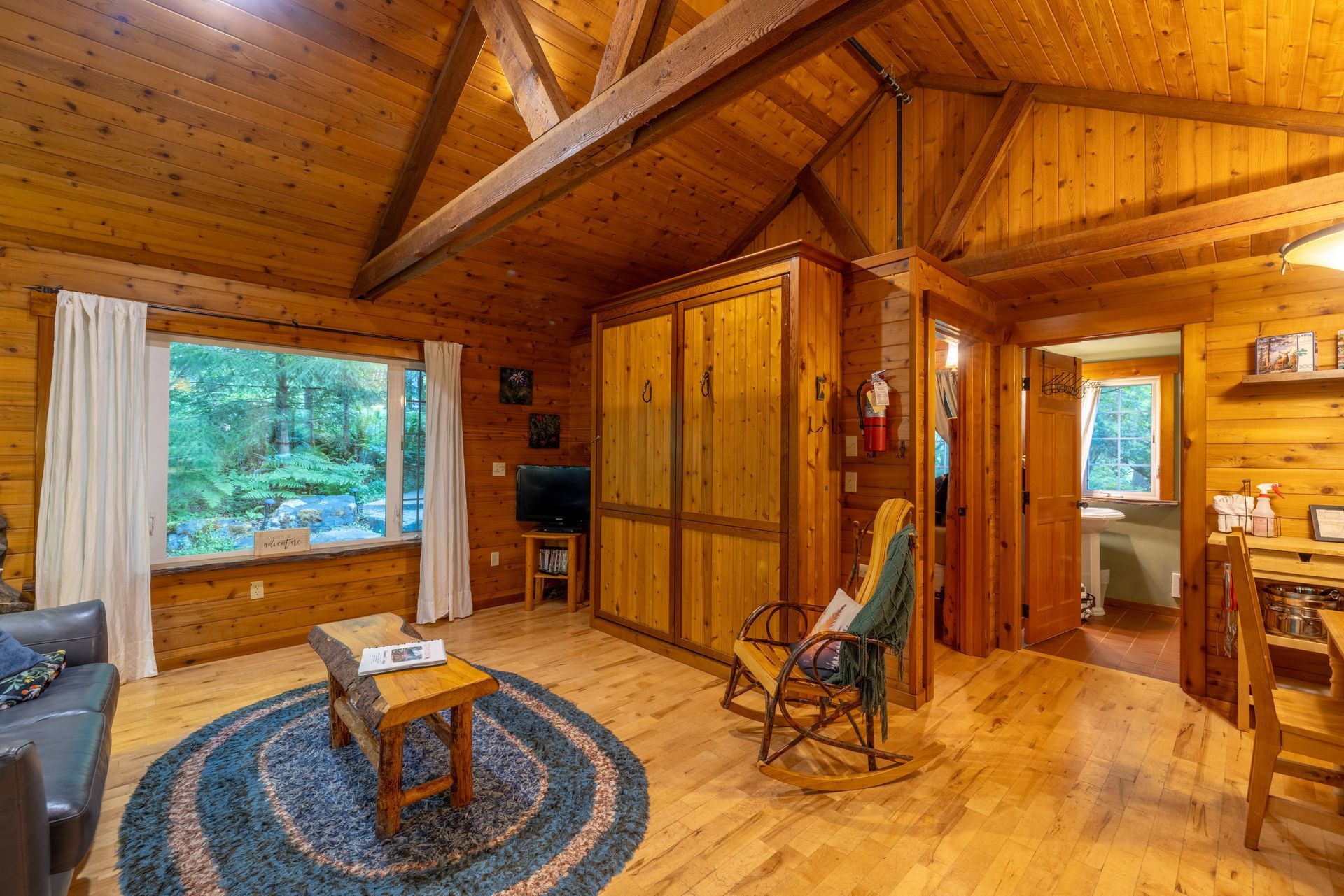 A living room with a fireplace and a trunk in front of a window.