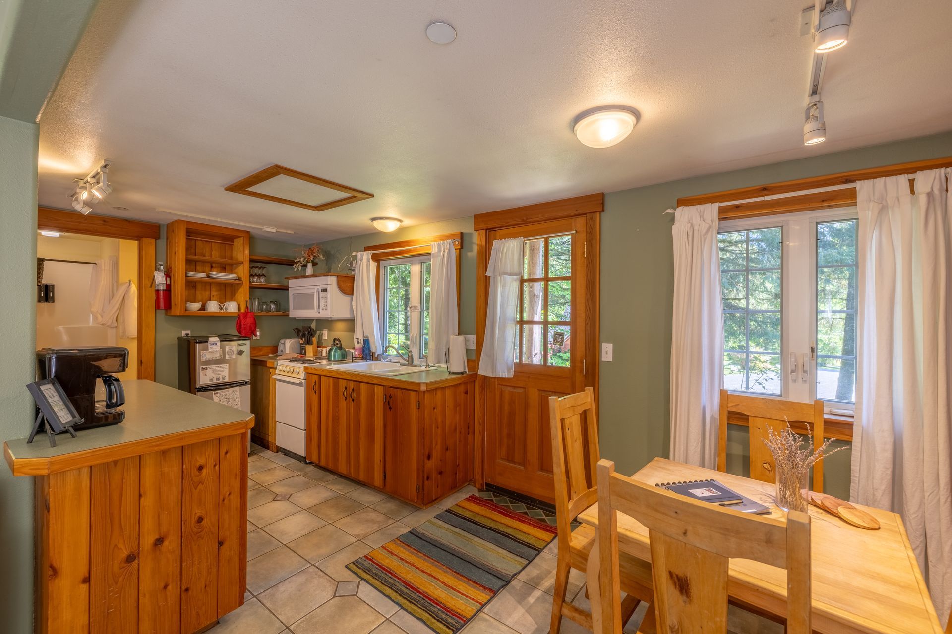 A kitchen with wooden cabinets and a couch in the background.