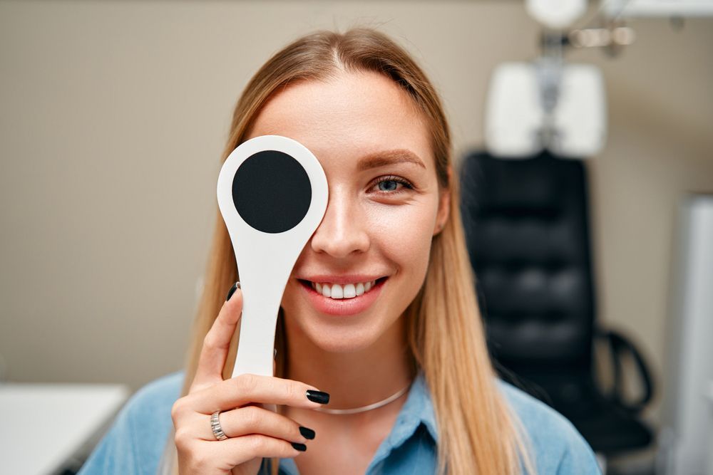 A woman is holding a circle in front of her eye