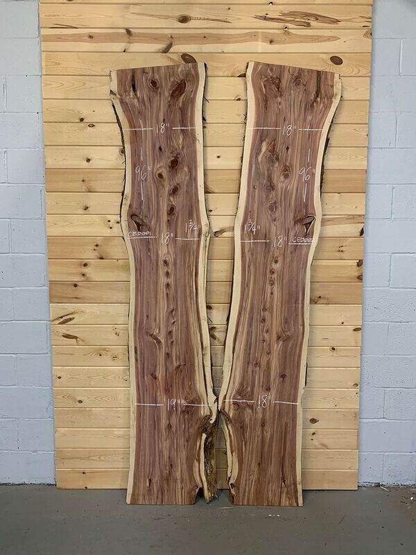 Two pieces of wood are sitting in front of a wooden wall.