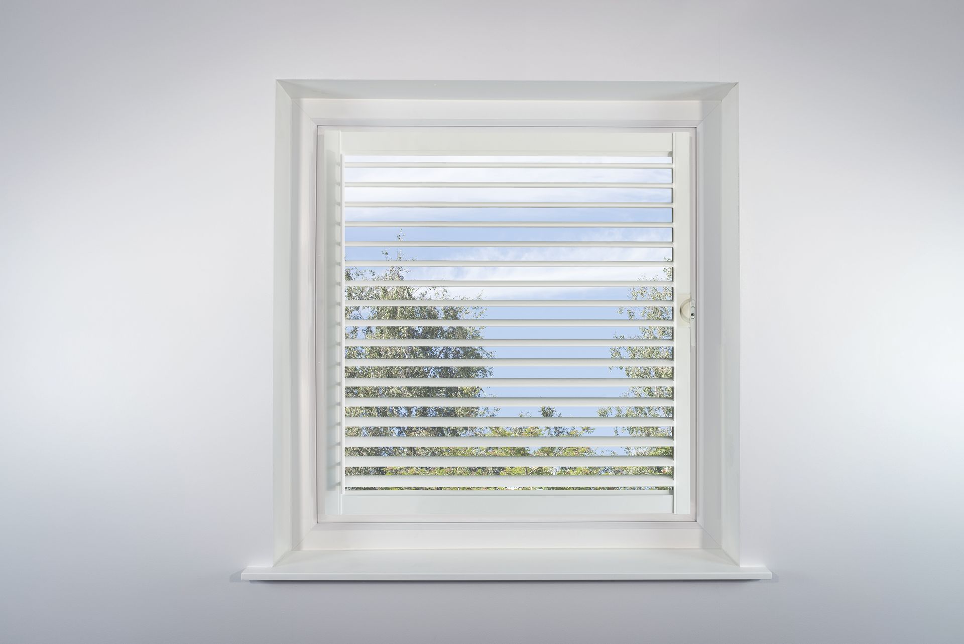 A window with blinds on it and a blue sky behind it.