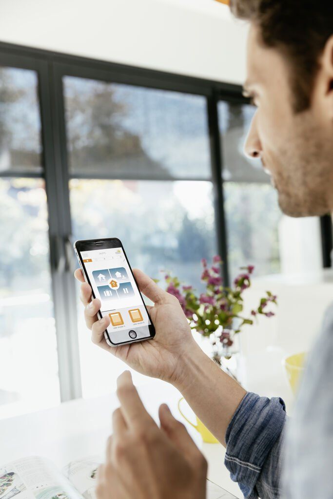 A man is holding a cell phone in his hand.