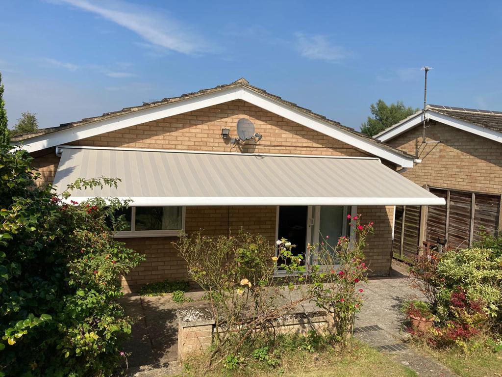 A brick house with a white awning on the front of it.