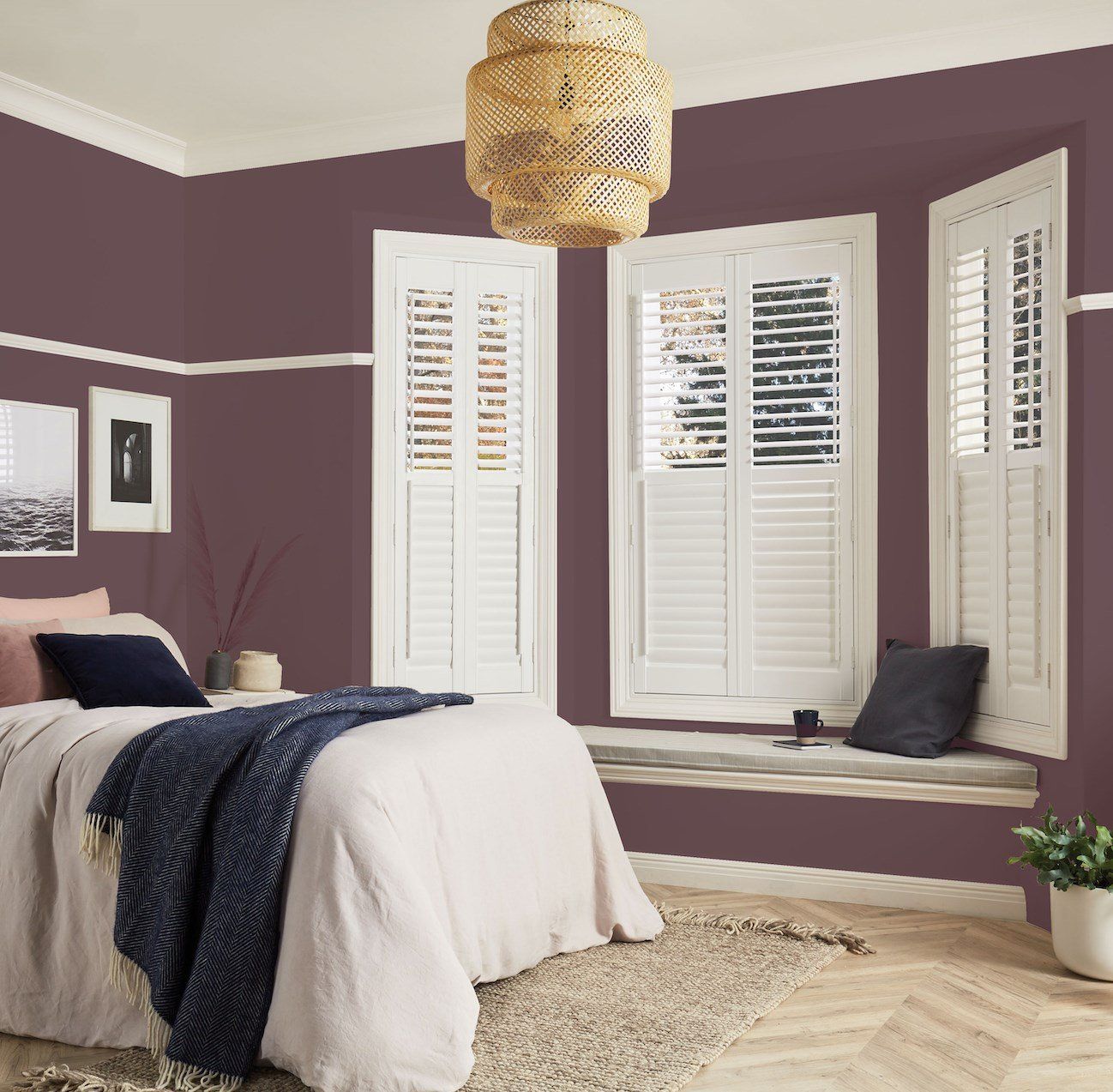 A bedroom with purple walls and white shutters
